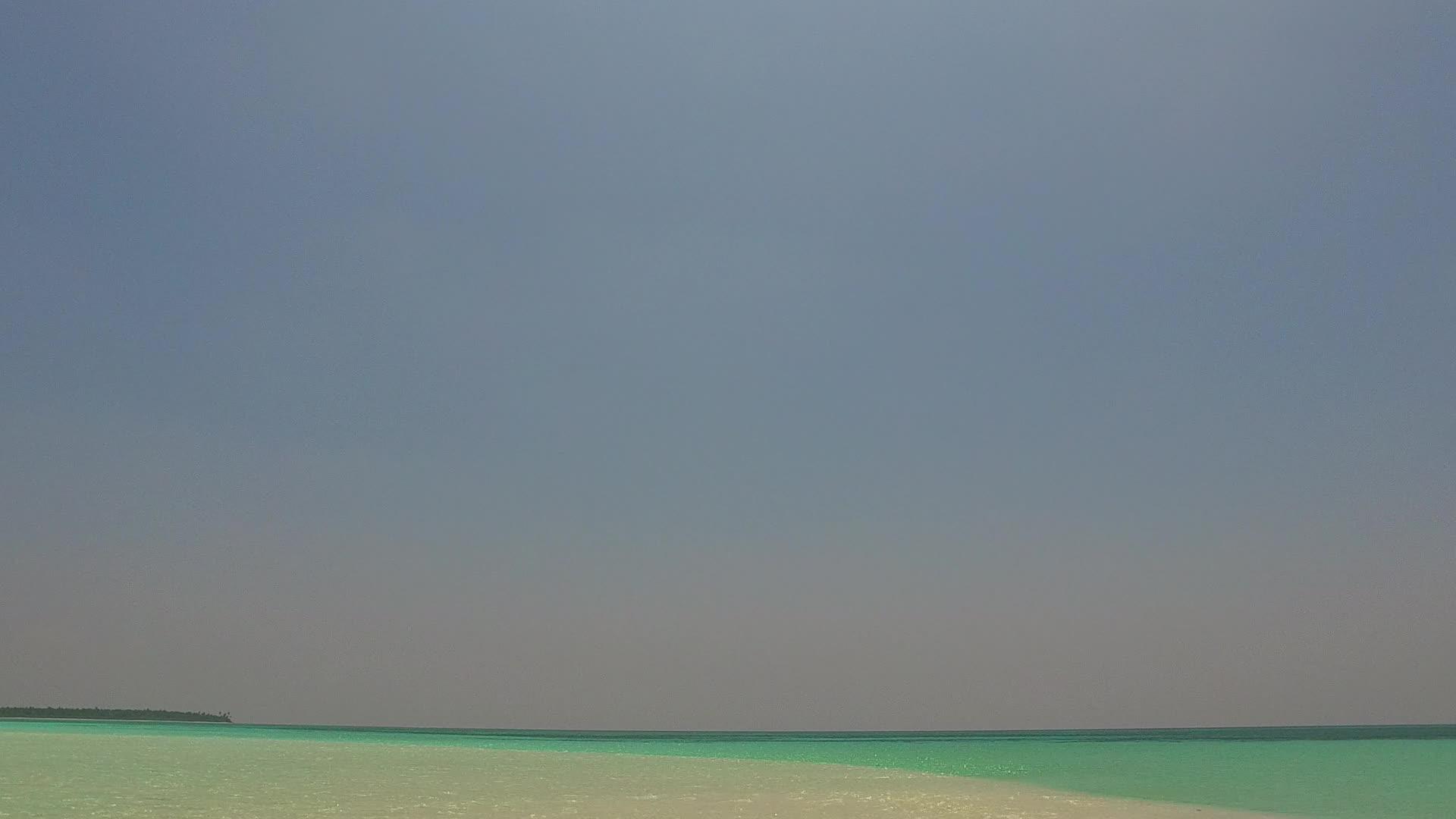 干净的沙质背景水蓝色的海洋宁静的海湾海滩时间无人机视频的预览图