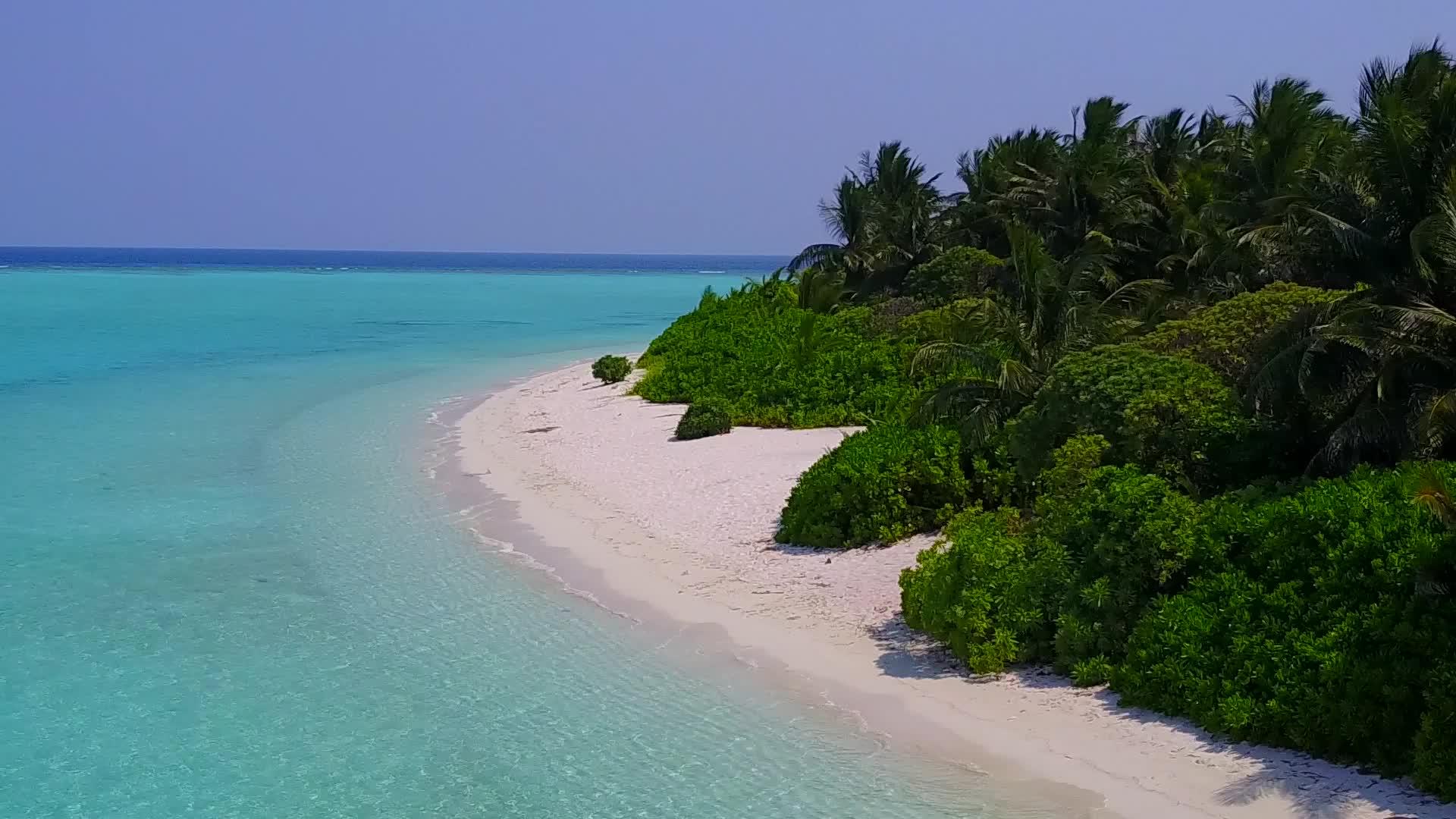 在蓝环礁湖和白色海滩的背景下沿着海滨海滩航行视频的预览图