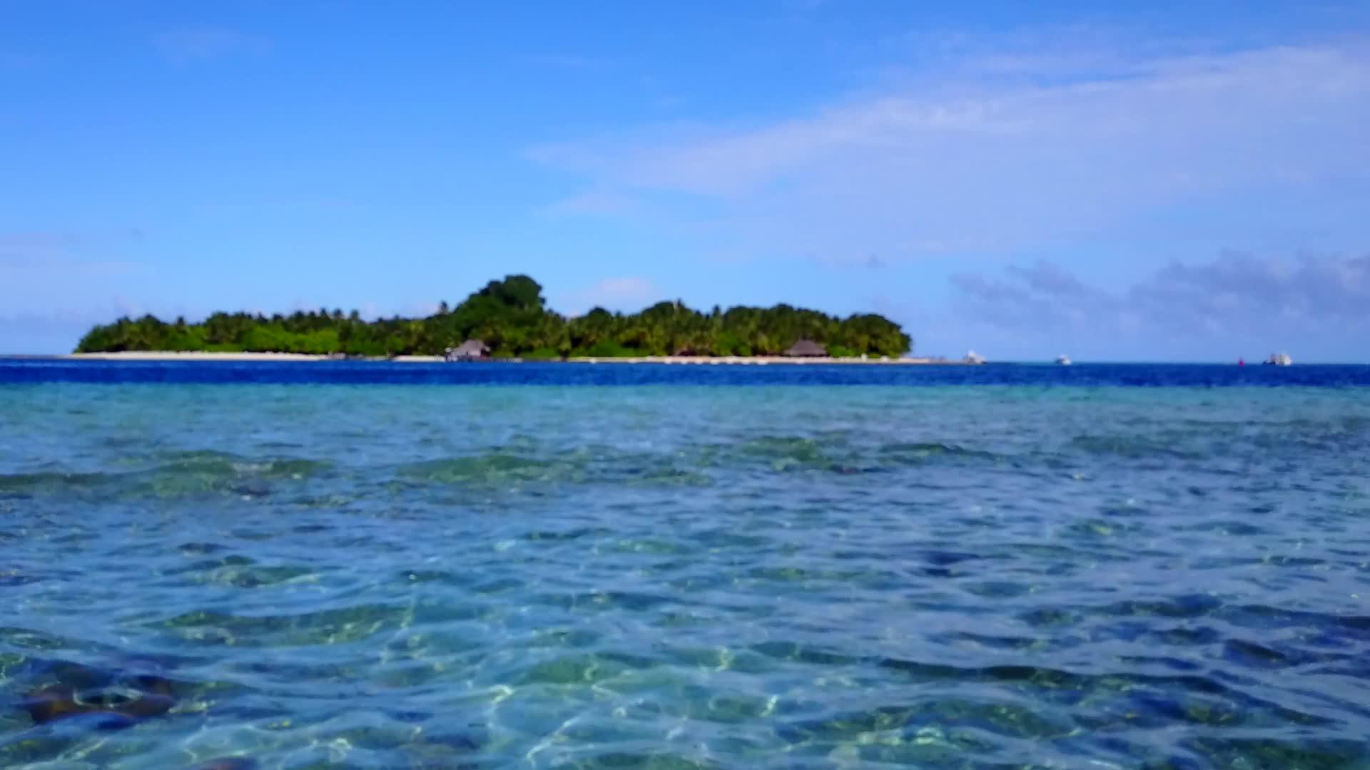 豪华的海岸线以蓝绿色的海洋和白色的海滩为背景全天打破海滩视频的预览图