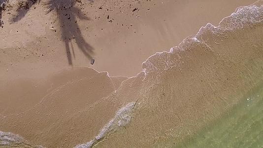 在白沙的背景下蓝色的水流打破了海湾海滩的空抽象视频的预览图
