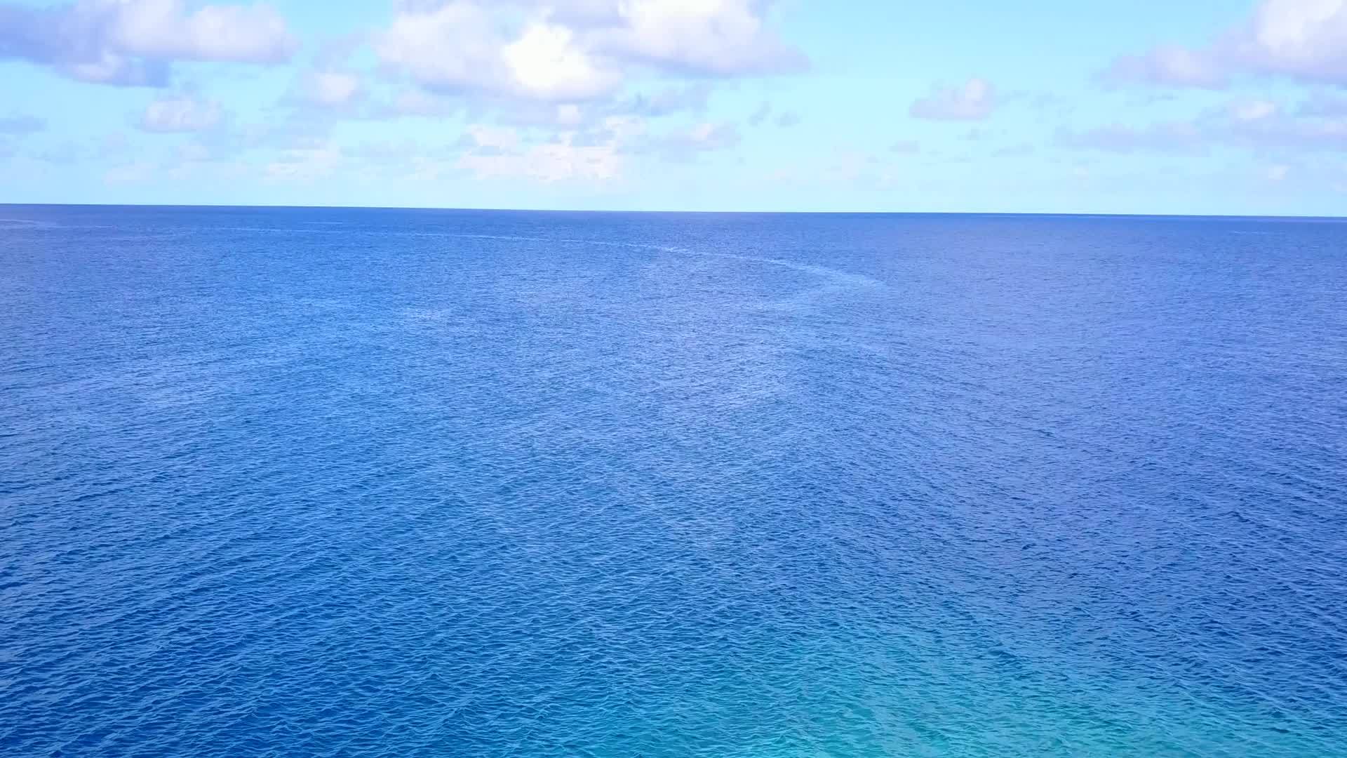 沿海海滩以水、蓝色海洋和白沙为背景视频的预览图