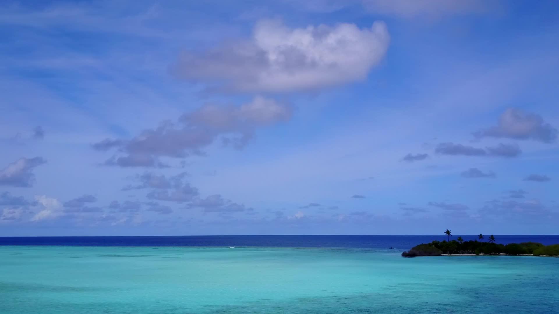 在绿松石海和白色海滩的背景下放松沿海海滩航行的无人机景观视频的预览图