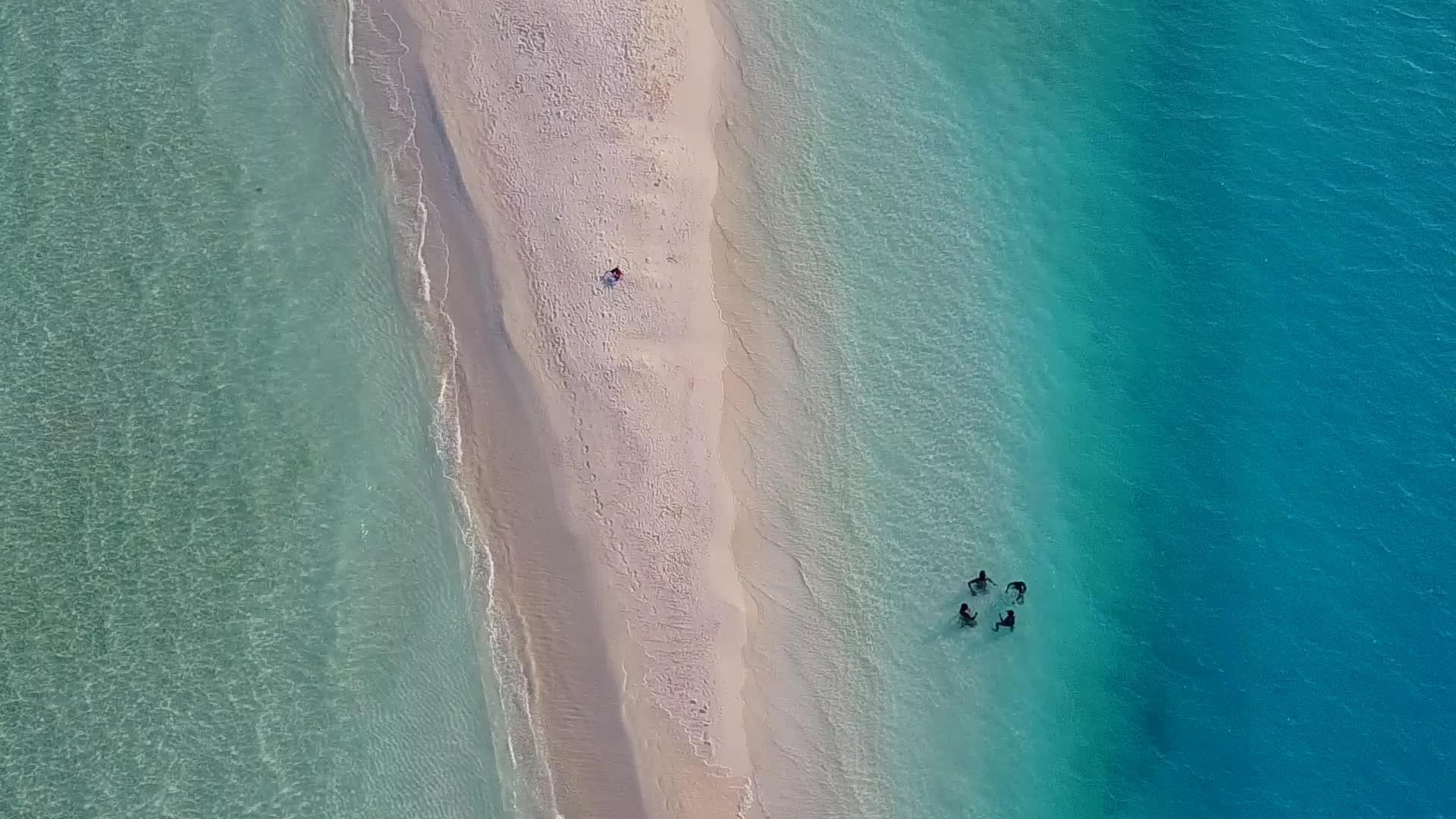 空中无人飞机在蓝绿色海洋和浅沙的背景下航行视频的预览图