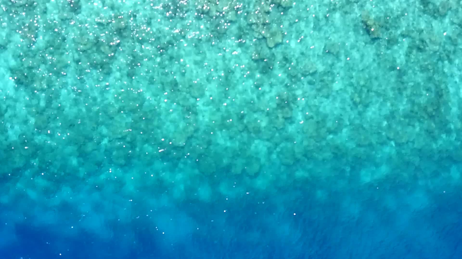 无人驾驶飞机在空中飞行以蓝海和白沙的背景打破了海底海滩视频的预览图