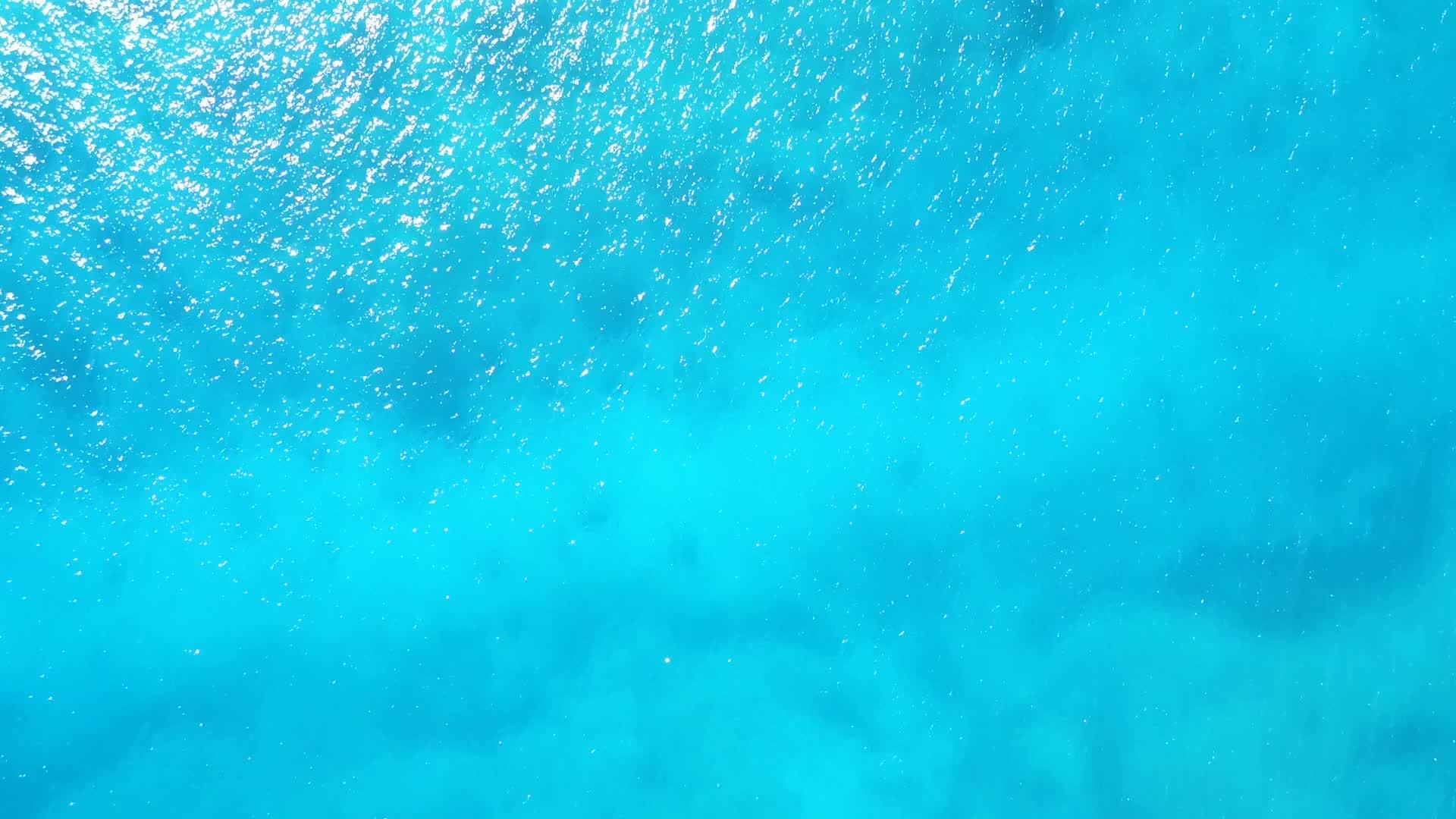 蓝色的水蓝色的海和白色的以海和白沙为背景视频的预览图