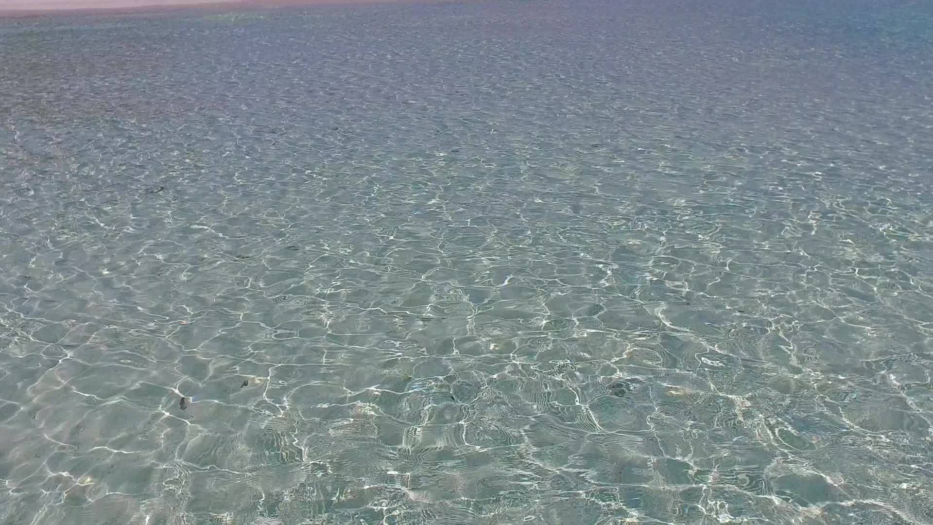 透明的大海和干净的沙质背景从空中俯瞰美丽的海滩视频的预览图