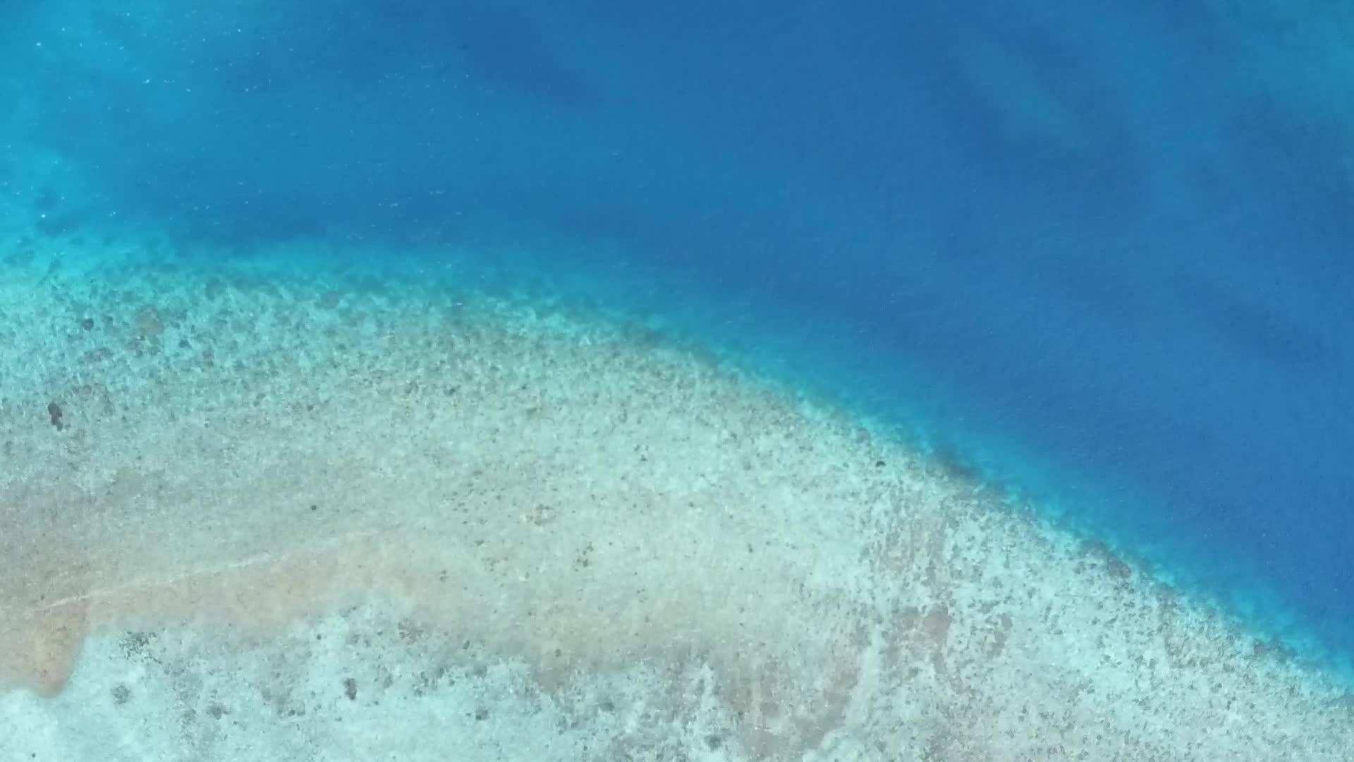 空中无人驾驶飞机的天空通过海水透明的水和白色的沙土背景视频的预览图