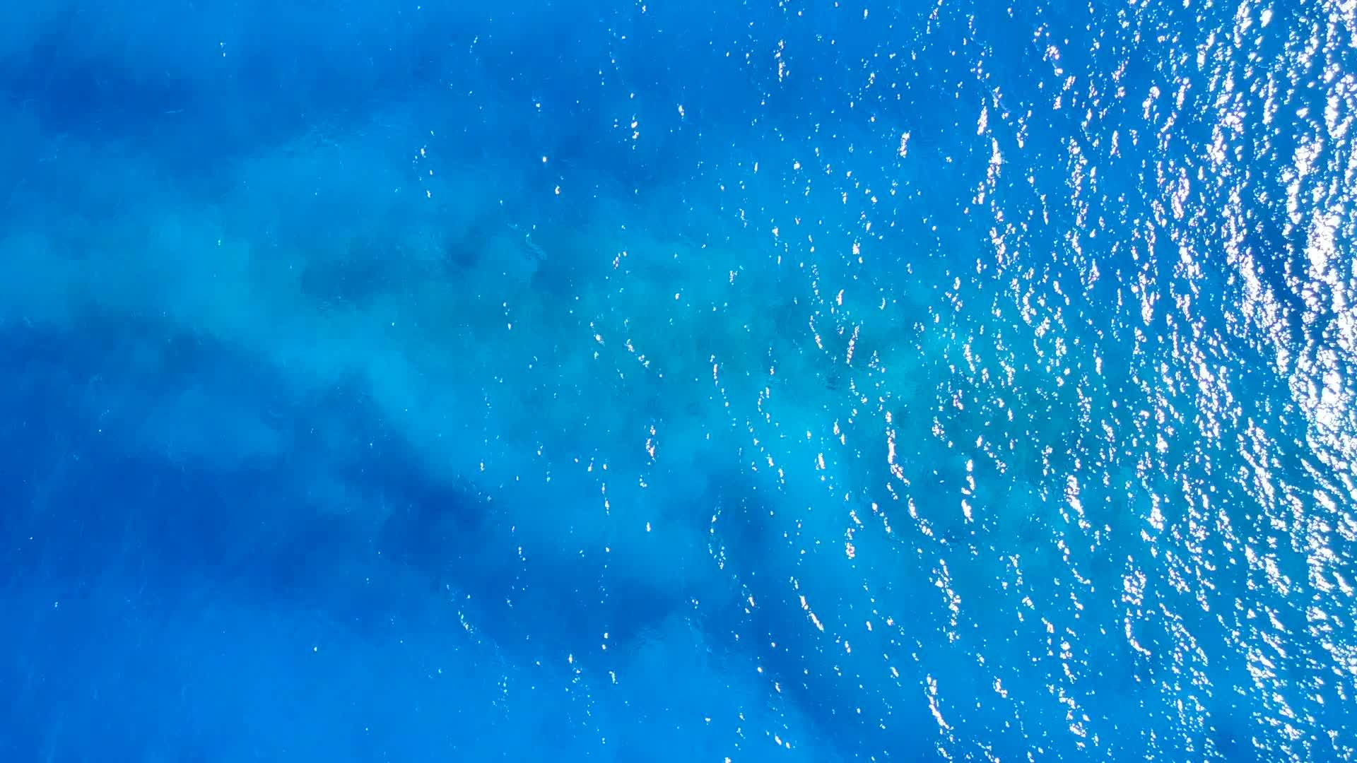 在蓝色、绿色的水和白色的沙子的背景下宁静的海滩旅行的无人机景观纹理视频的预览图