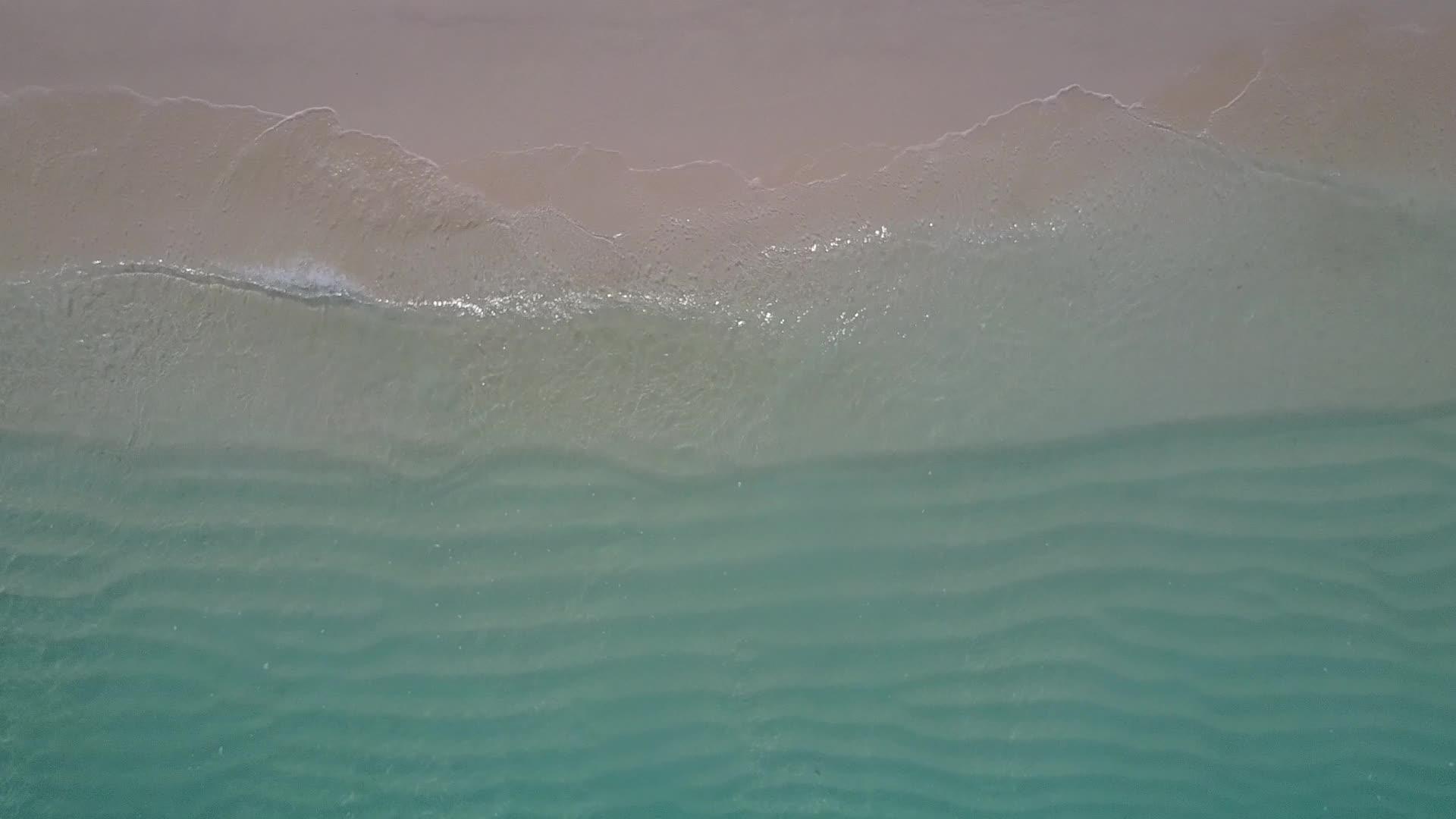 蓝色的海洋通过蓝色的海洋和白色的沙子打破了完美的海滩海景视频的预览图
