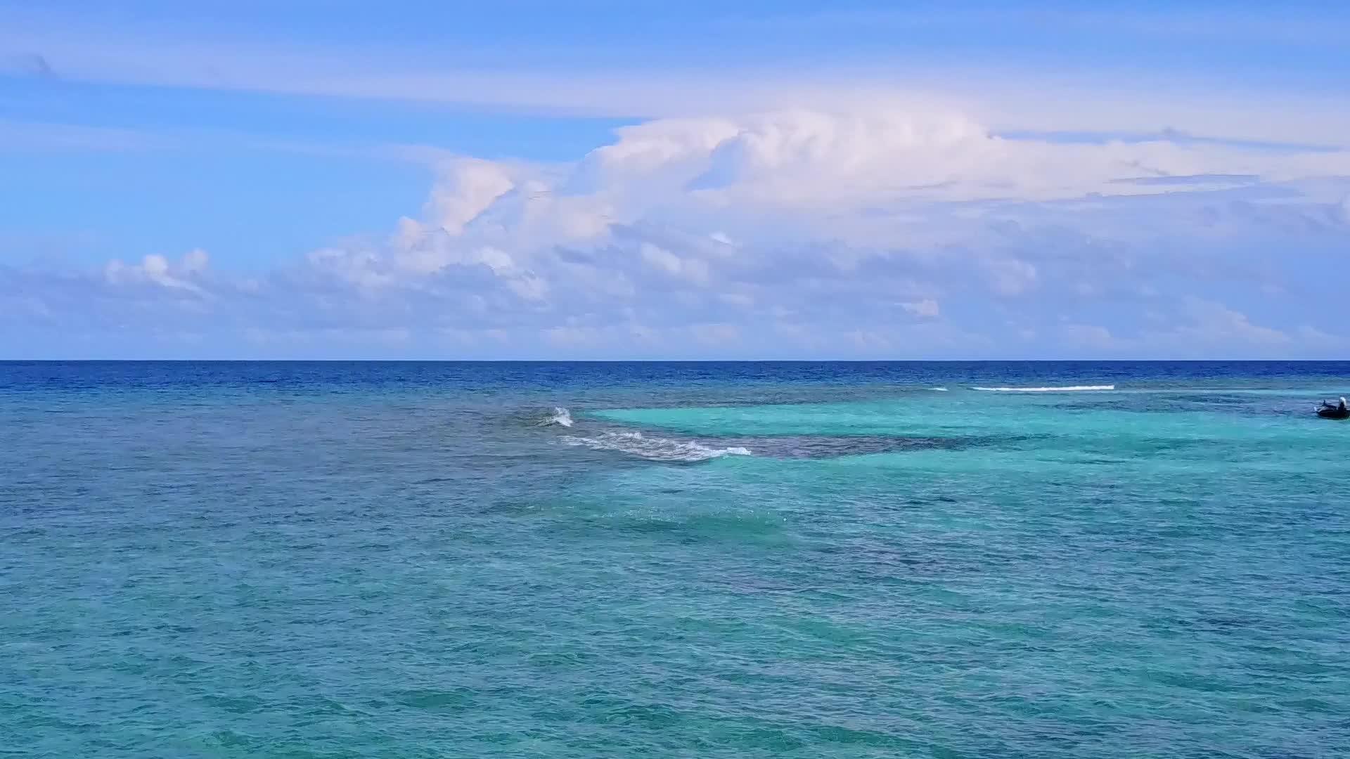 美丽的海洋观光者以绿色的海洋和白色的沙尘为背景在海滩上航行视频的预览图