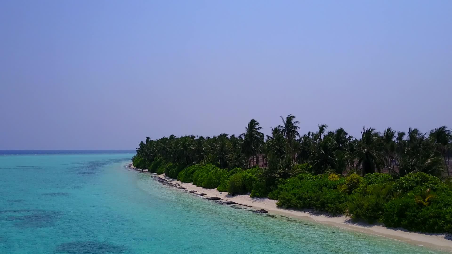 在蓝环礁湖和白色海滩的背景下在空中无人驾驶视频的预览图