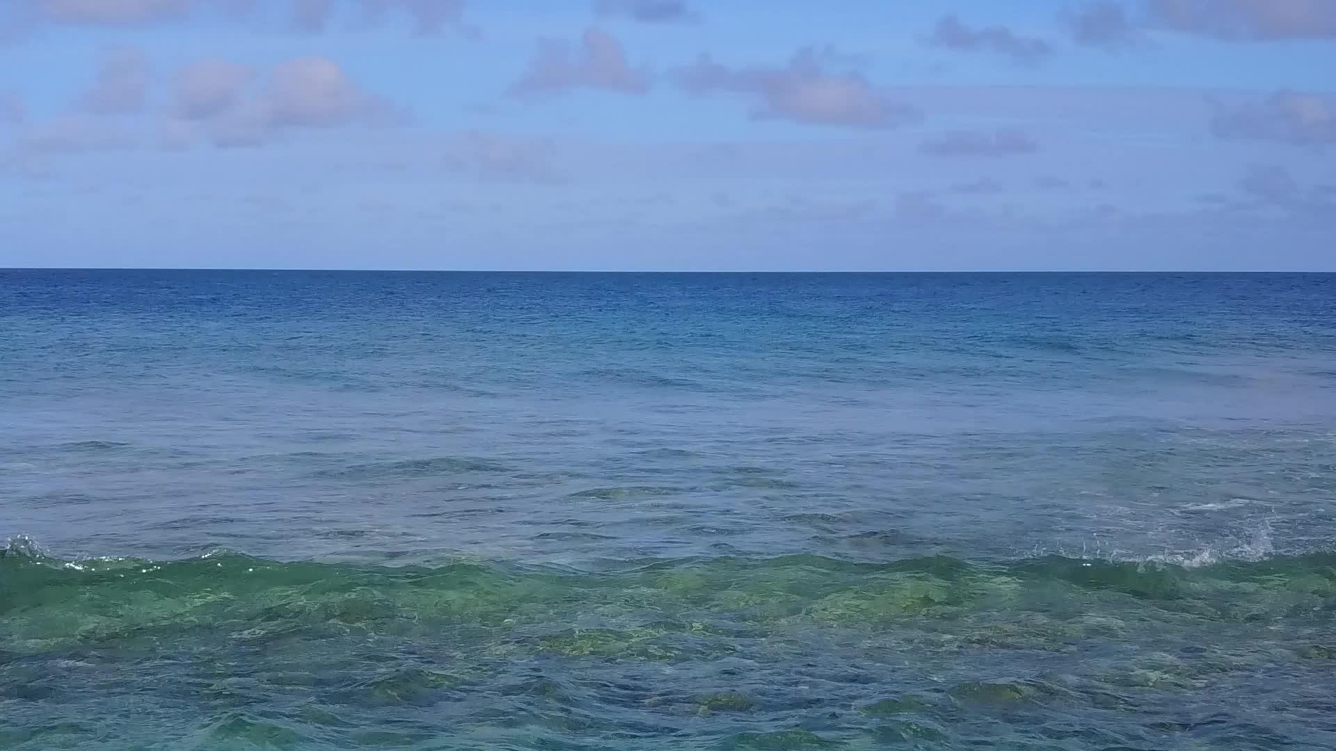 在水蓝色的海洋和明亮的沙滩下的无人机海滩视频的预览图