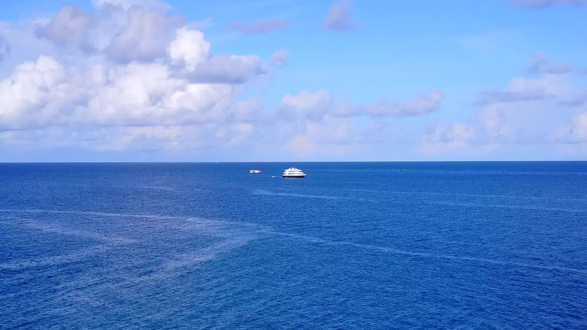 沿着蓝色海洋和浅沙背景的蓝色海洋视频的预览图