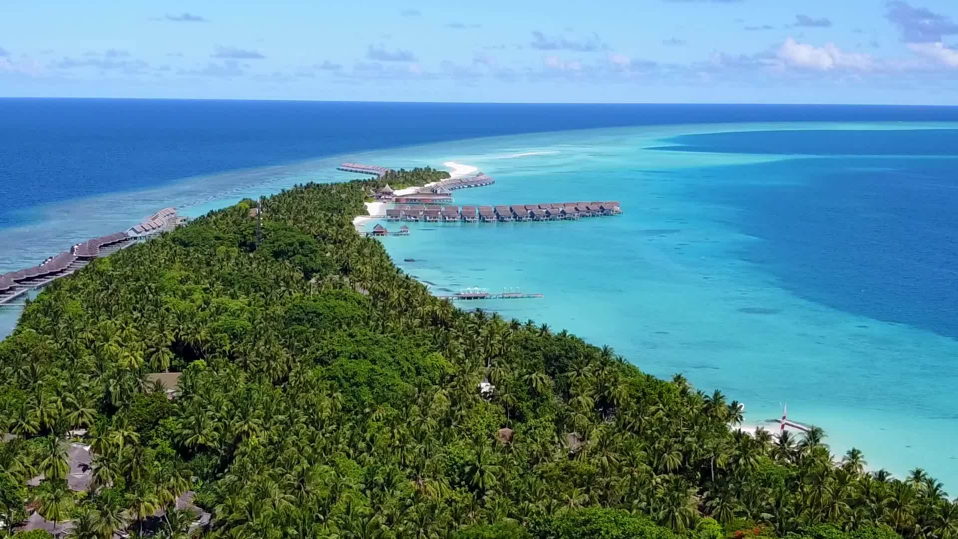 在蓝色环礁湖和白色沙滩为背景观赏豪华岛屿海滩度假的天空视频的预览图