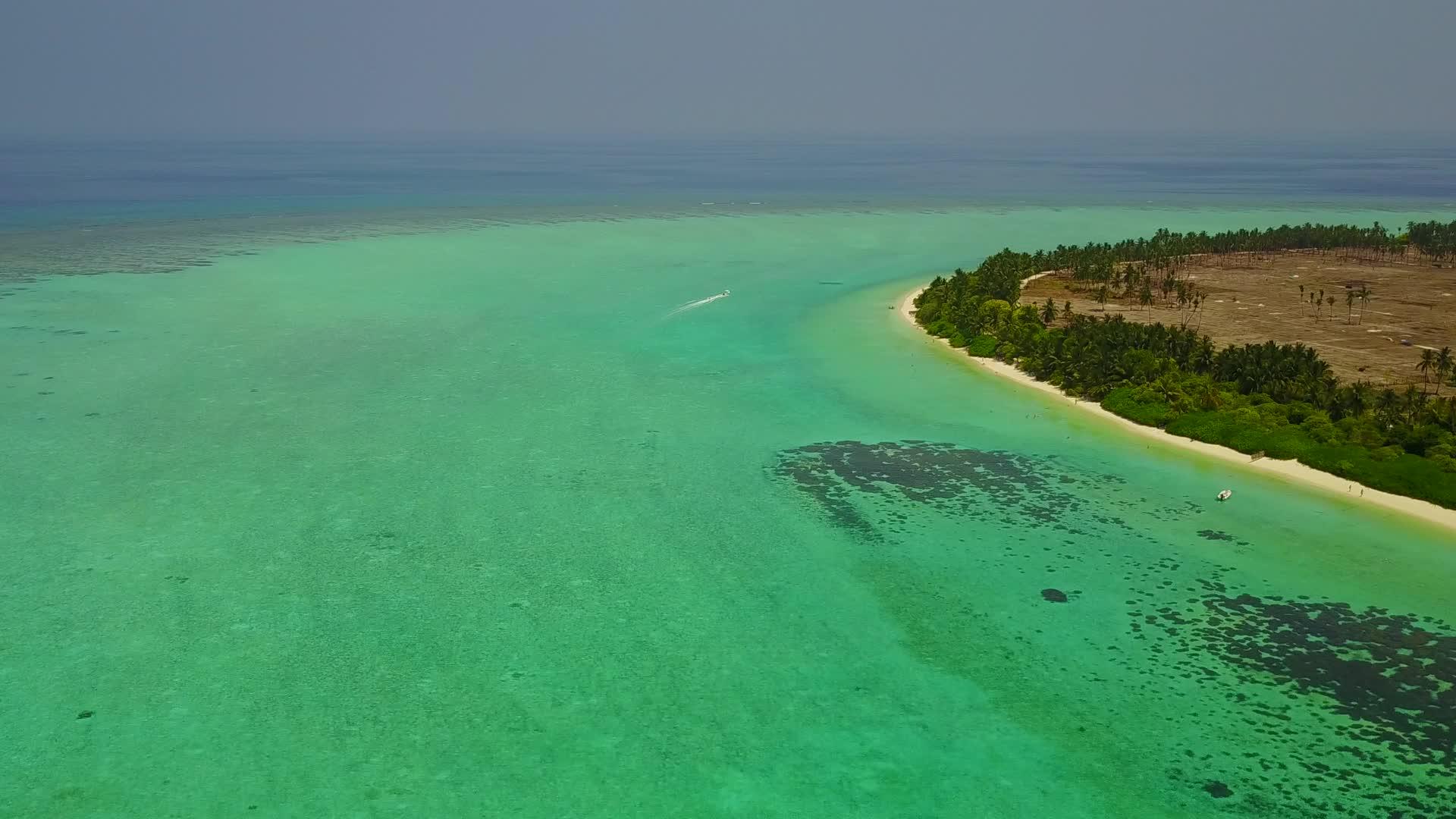 利用蓝绿色的水和干净的沙土背景出海的海滨海滩视频的预览图