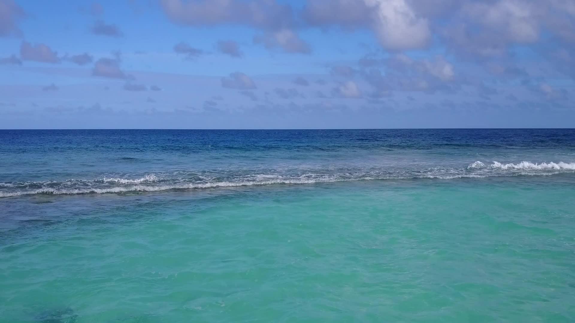 蓝绿色环礁湖和白色沙滩的背景打破了豪华的泻湖海滩视频的预览图