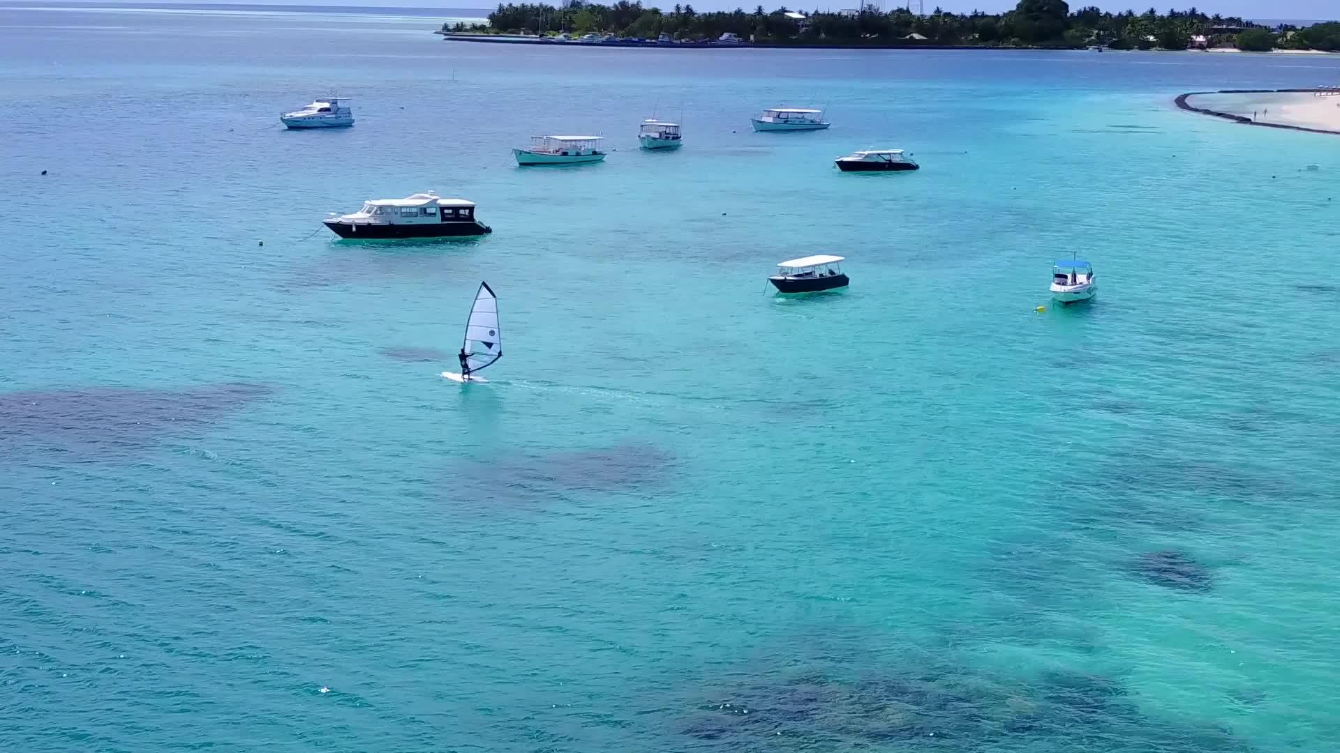 在蓝色海洋和白色沙滩的背景下航行的无人驾驶度假胜地视频的预览图