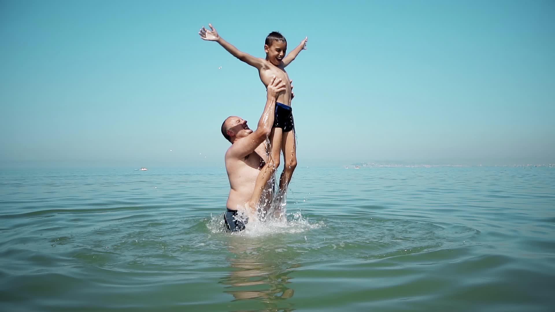 父亲把儿子扔在海滩上认为一个友好的家庭很慢视频的预览图