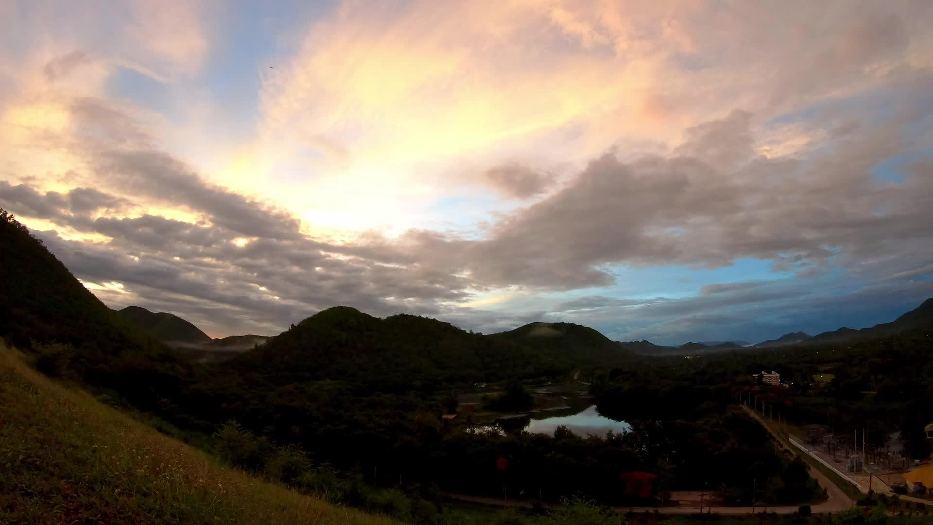 太阳和云的反射在泰国法塔卡的背景山上迅速移动视频的预览图