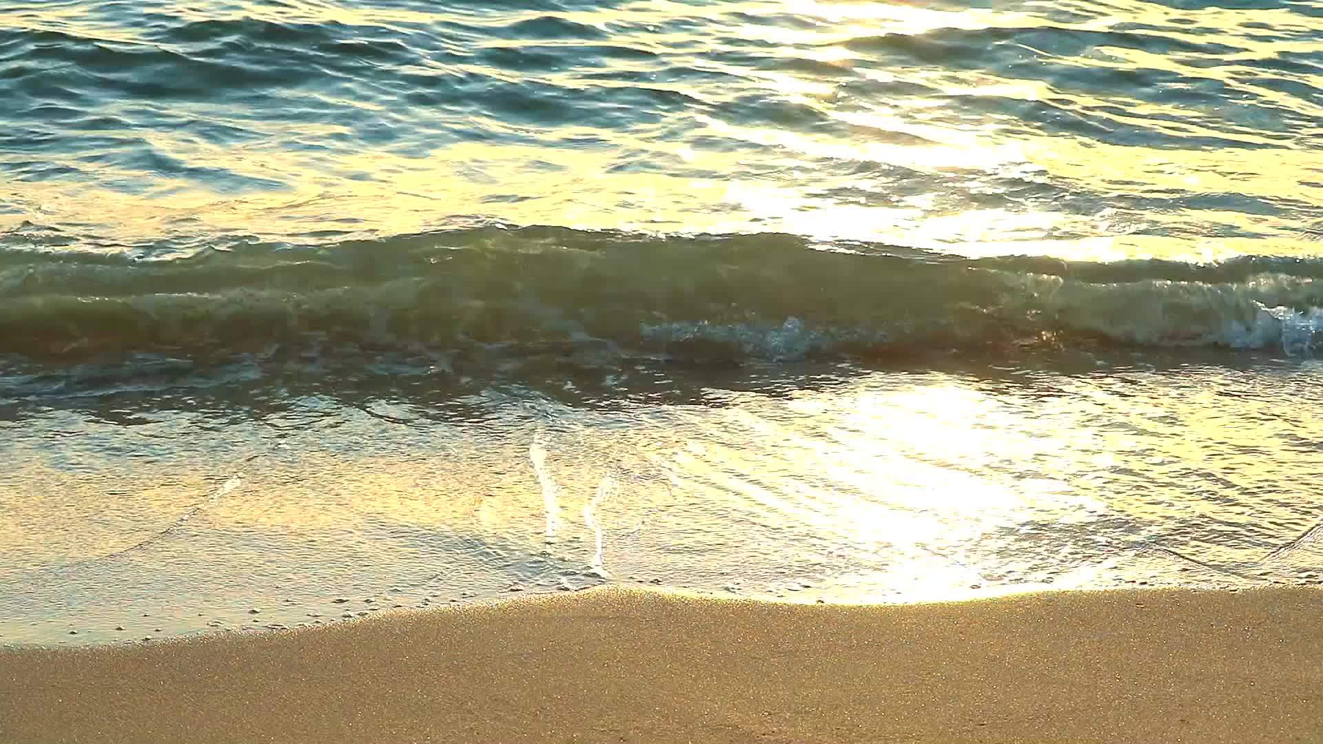 从海浪到海滩反射阳光海滩上有泡沫波视频的预览图