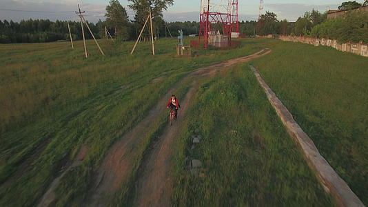 少年骑自行车在农村的空中观看视频的预览图