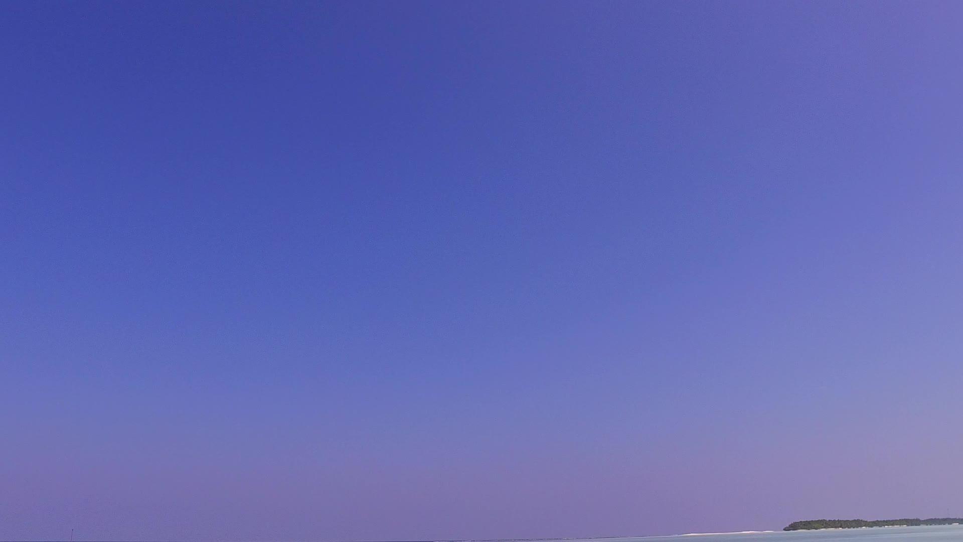 蓝绿环礁湖和波浪附近的白色海滩背景热带旅游海滩视频的预览图