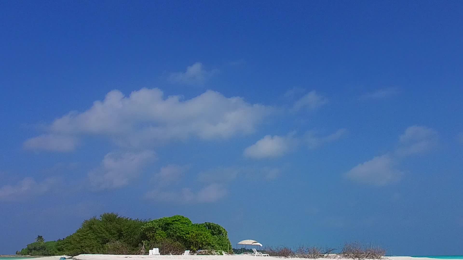 白沙背景在棕榈树附近的蓝色海滩上航行视频的预览图