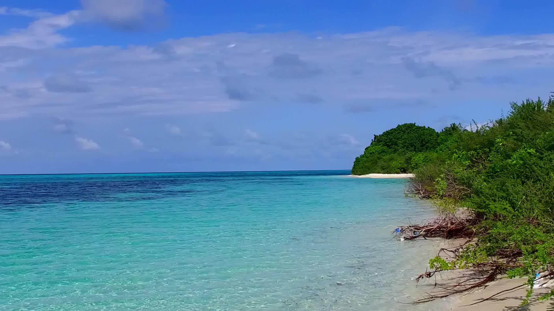 安静的岛屿海滩海滩依托浅环礁湖和珊瑚礁附近的浅沙背景视频的预览图