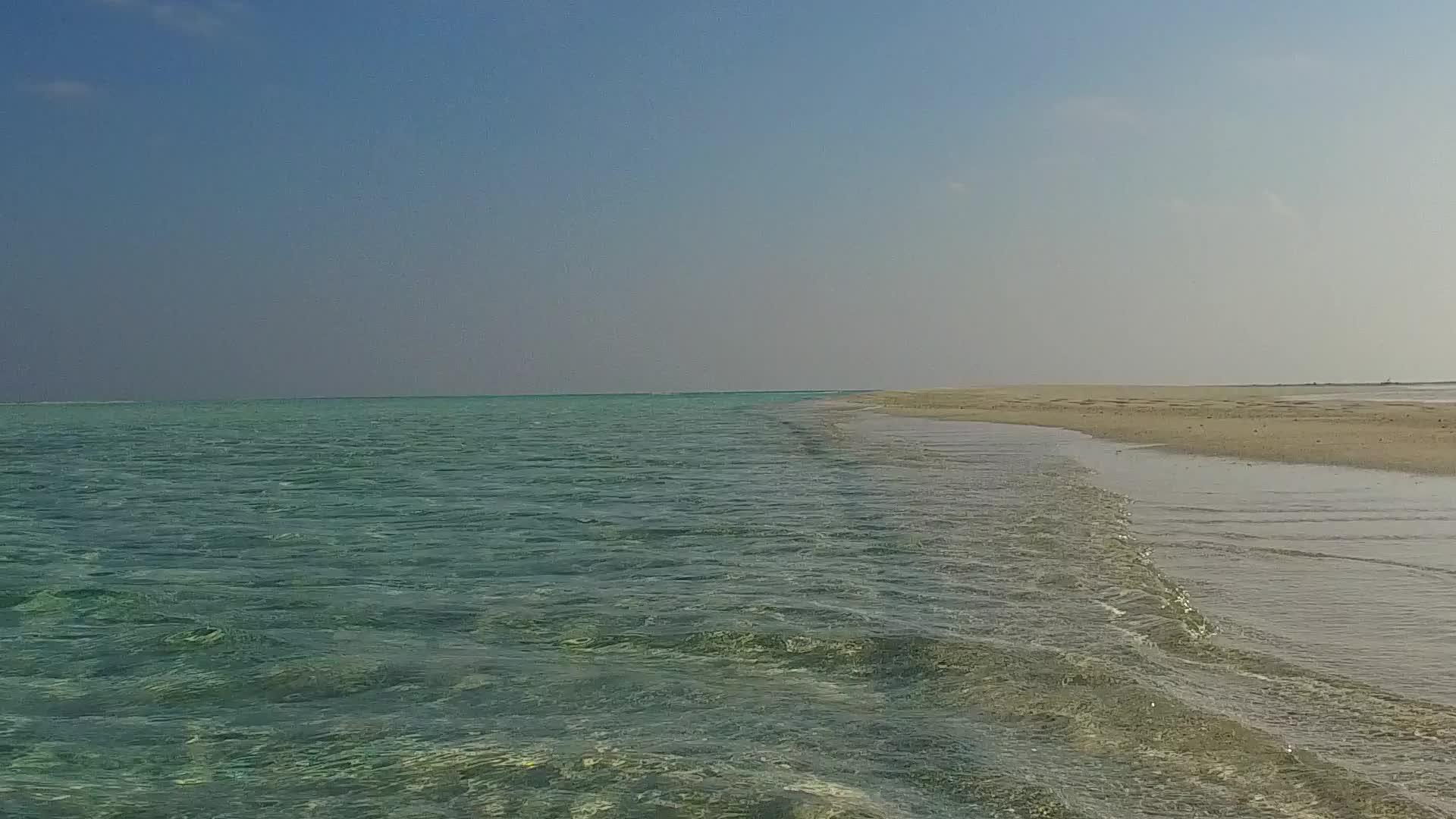蓝色环礁湖和接近冲浪的白色沙滩背景阳光明媚沿海潮湿视频的预览图