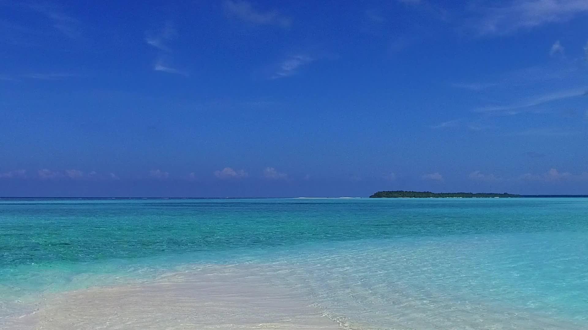 沿海海滩的休闲生活通过浅水和近距离冲浪的白色海滩背景视频的预览图