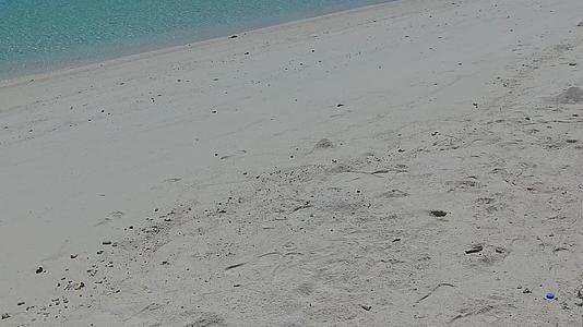 夏季旅游由绿松石环礁湖进行海浪附近有白沙背景视频的预览图