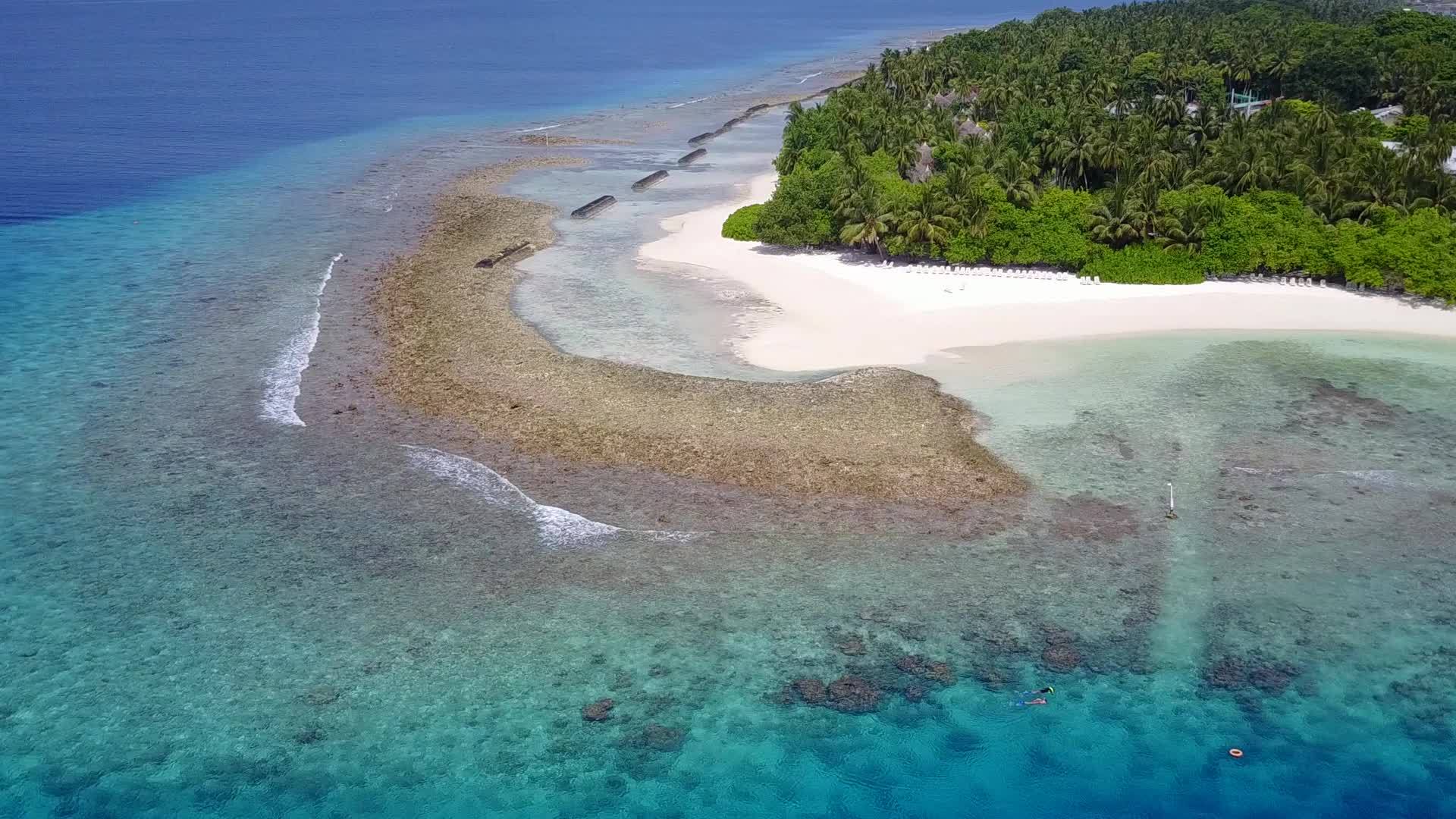蓝绿环礁湖和白色沙滩背景靠近度假胜地以宽角抽象为背景视频的预览图
