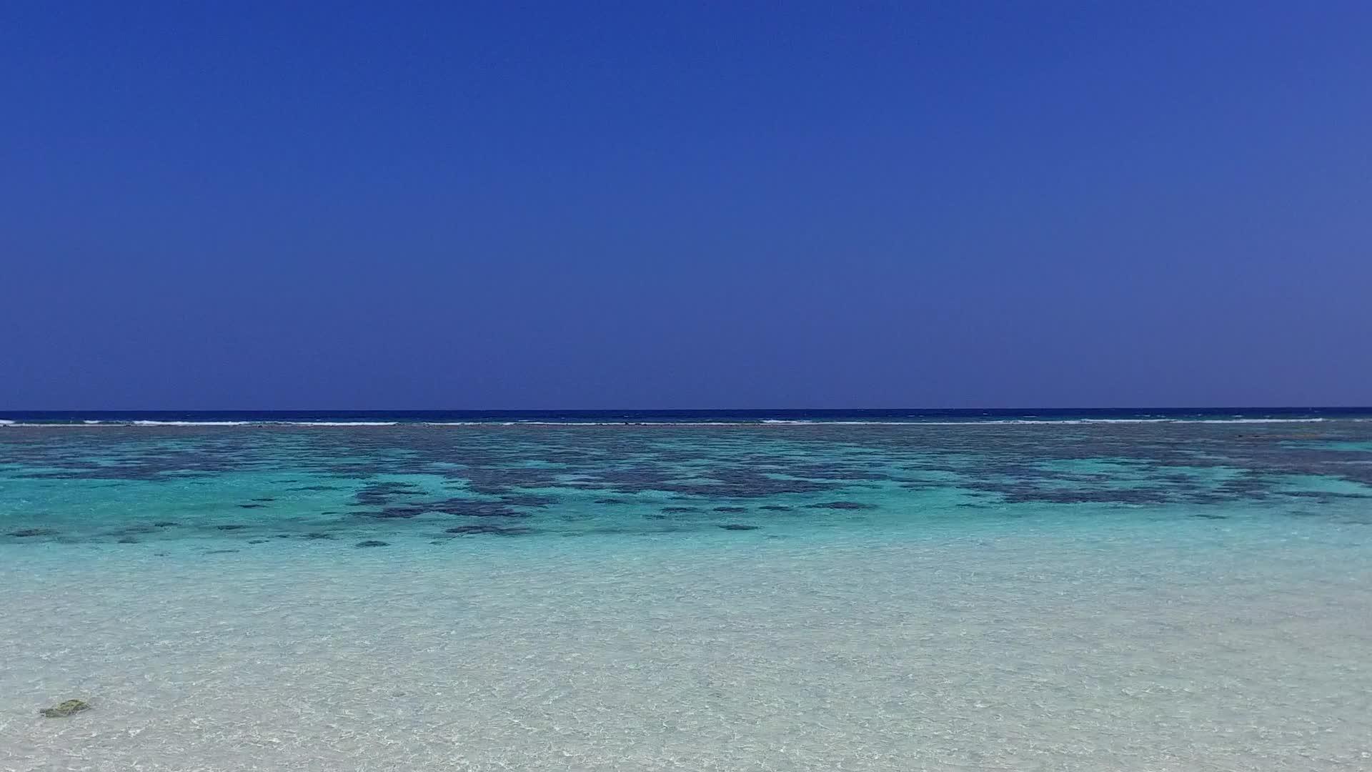 阳光明媚的海滨海滩位于度假胜地附近背景为白色海滩视频的预览图