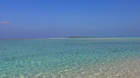 以蓝水和白色沙底为背景在度假胜地附近放松海岸视频的预览图