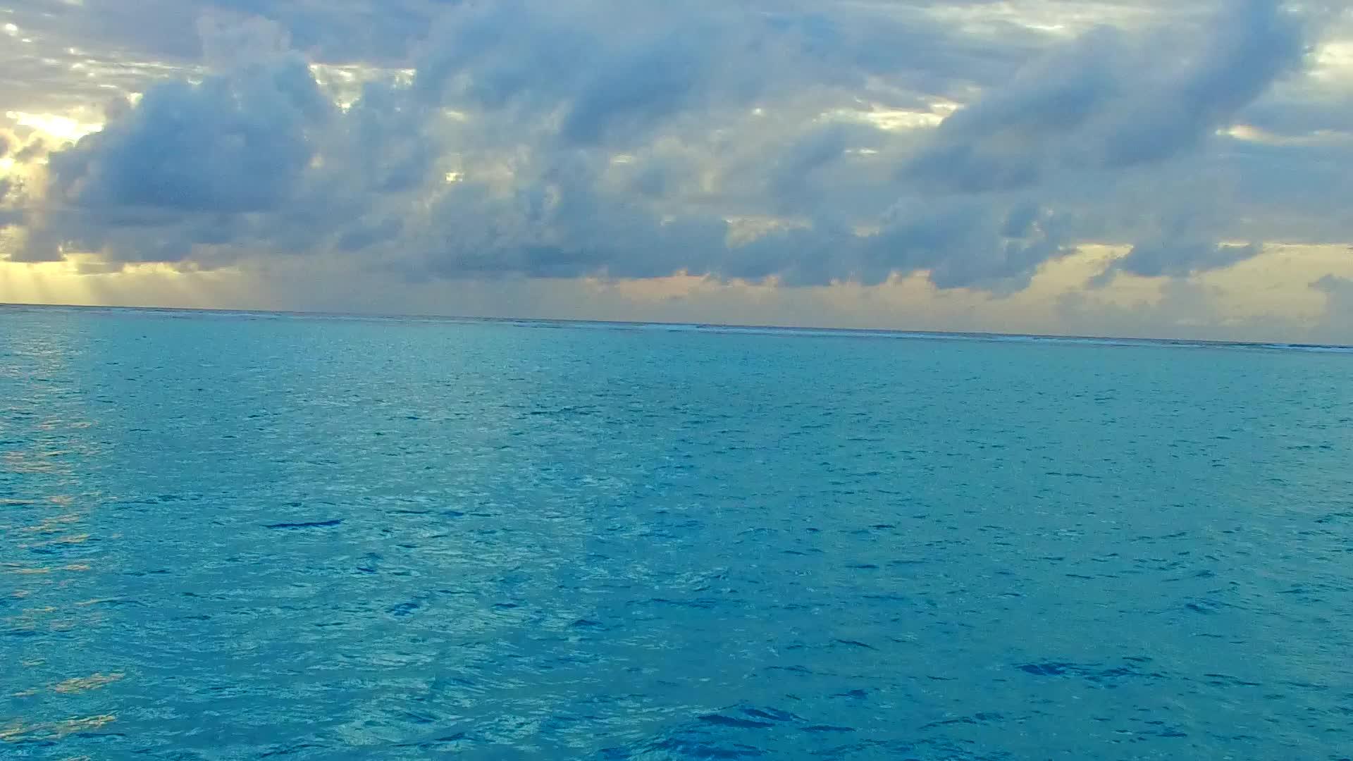 日落前从绿色的海洋和白色的沙底背景中出现的阳光奇特的海岸视频的预览图
