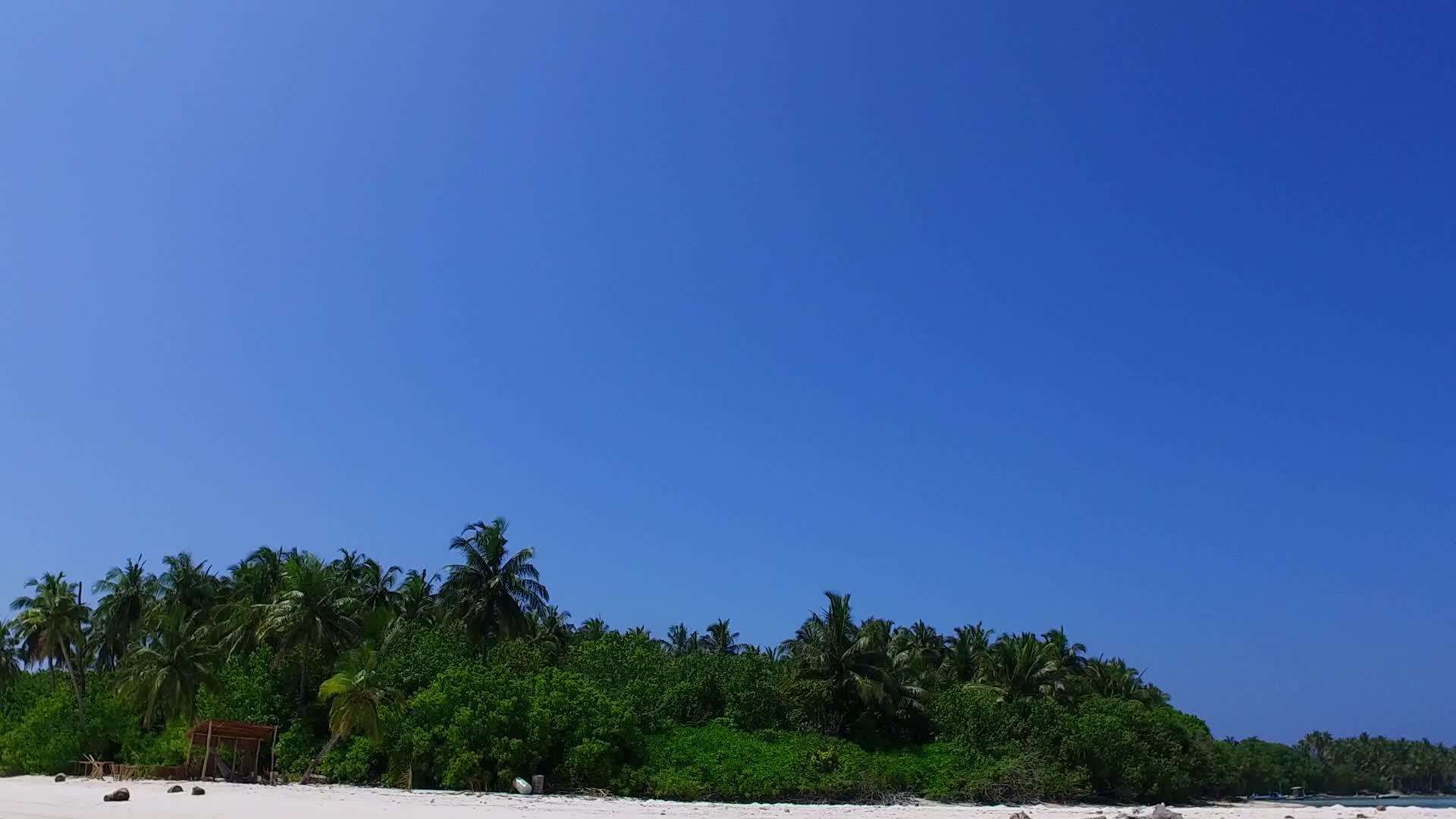 沿着蓝海航行在珊瑚礁附近有一个白色的沙子背景视频的预览图
