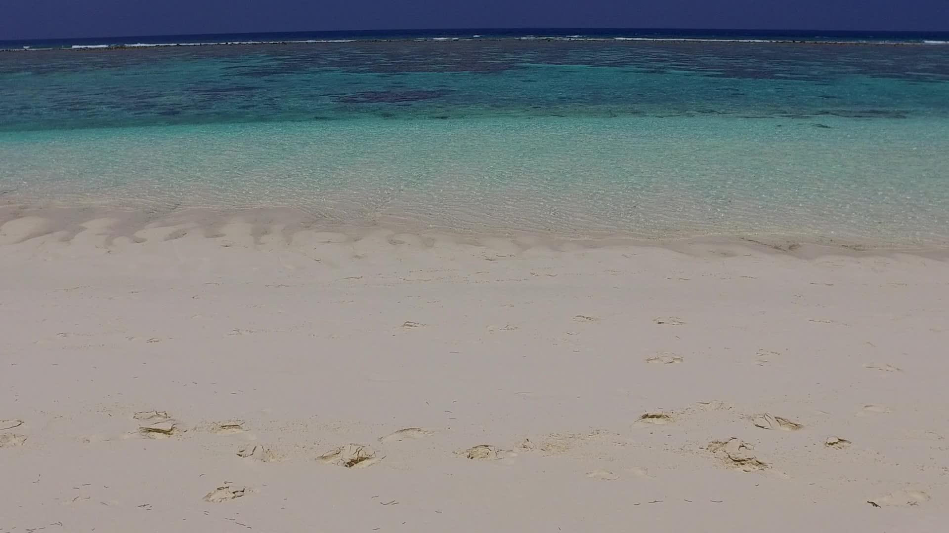 蓝色的大海和白色的沙滩沿着蓝色的海洋和接近冲浪的白色沙滩背景航行视频的预览图