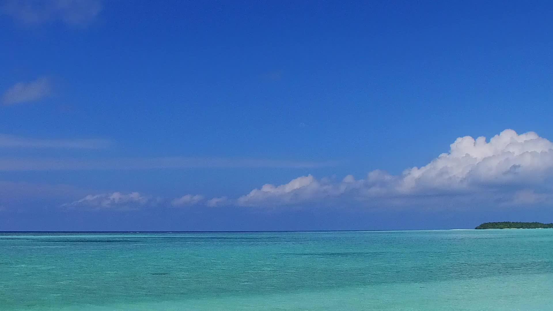 在蓝绿水和白沙的背景下在度假胜地附近的宁静海滩旅行视频的预览图