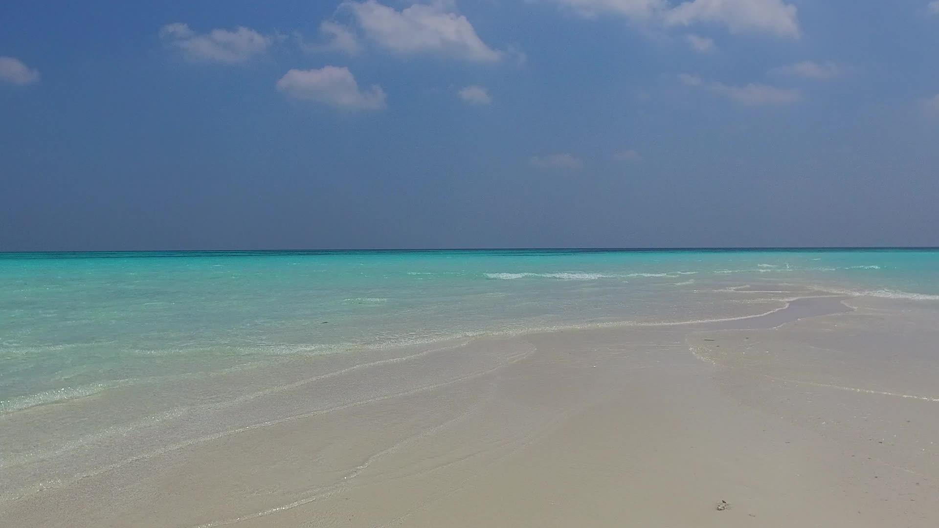 浅环礁湖和接近冲浪的白色沙滩背景的宽角天空放松以放松视频的预览图