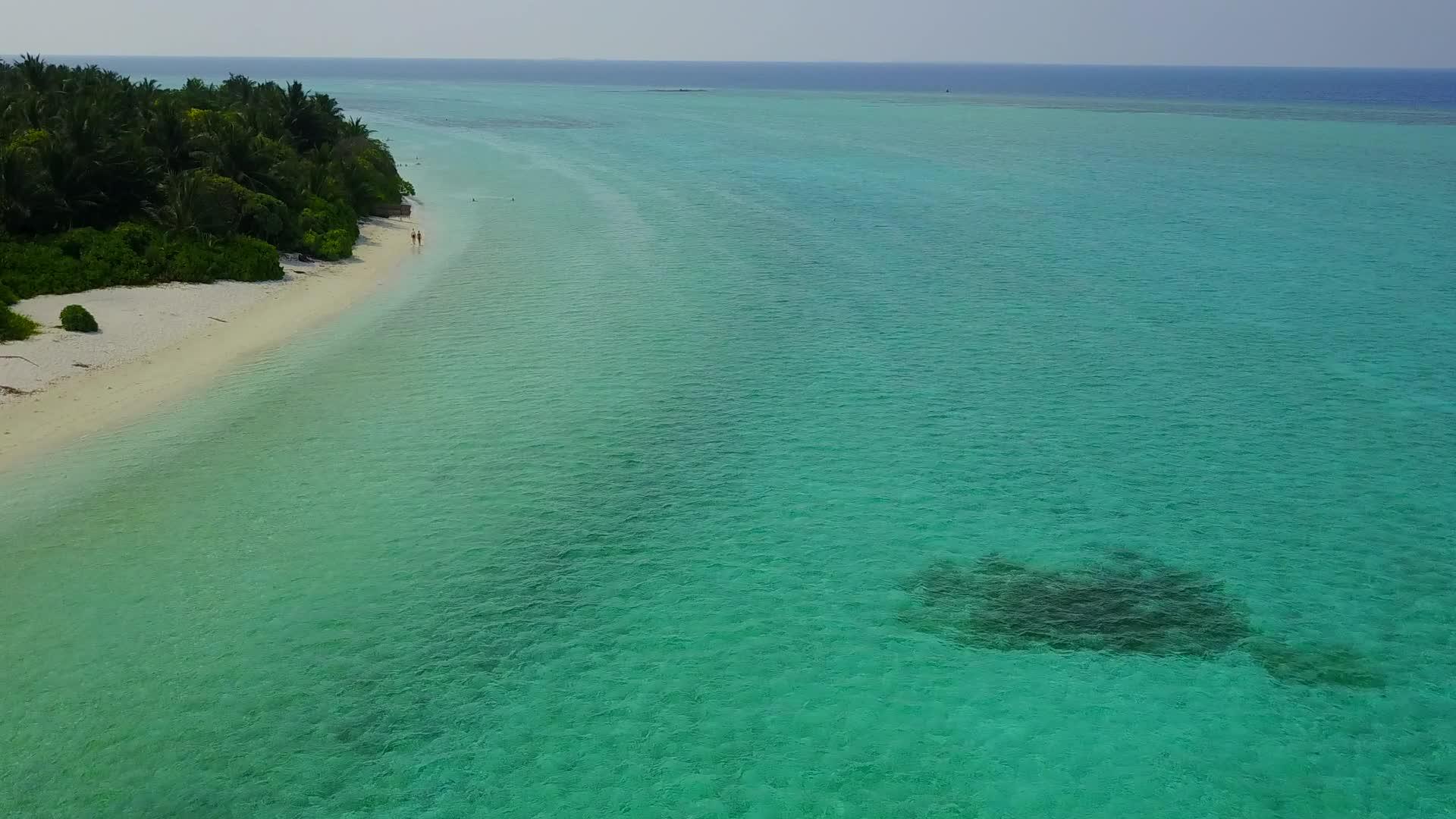 蓝绿色的大海和沙洲附近的白色海滩背景下田园诗般的海岸视频的预览图