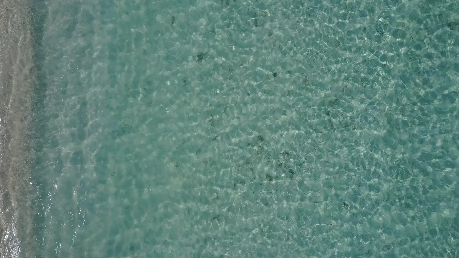以透明海洋和日出后的浅沙背景为例海平面之旅紧紧围绕着视频的预览图