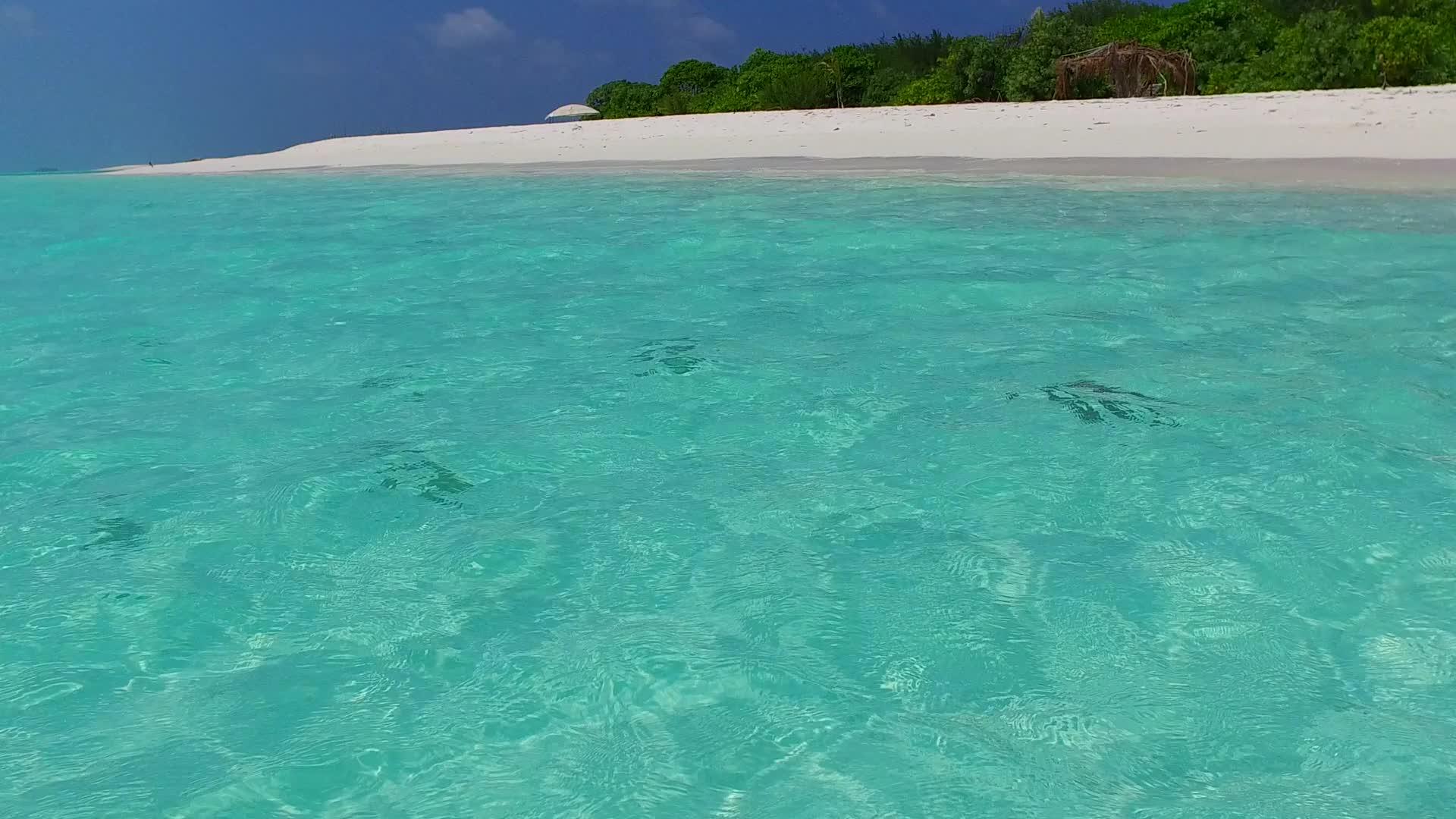 蓝绿色的海洋和田园诗般的海岸线背景为冲浪附近的白色沙滩视频的预览图