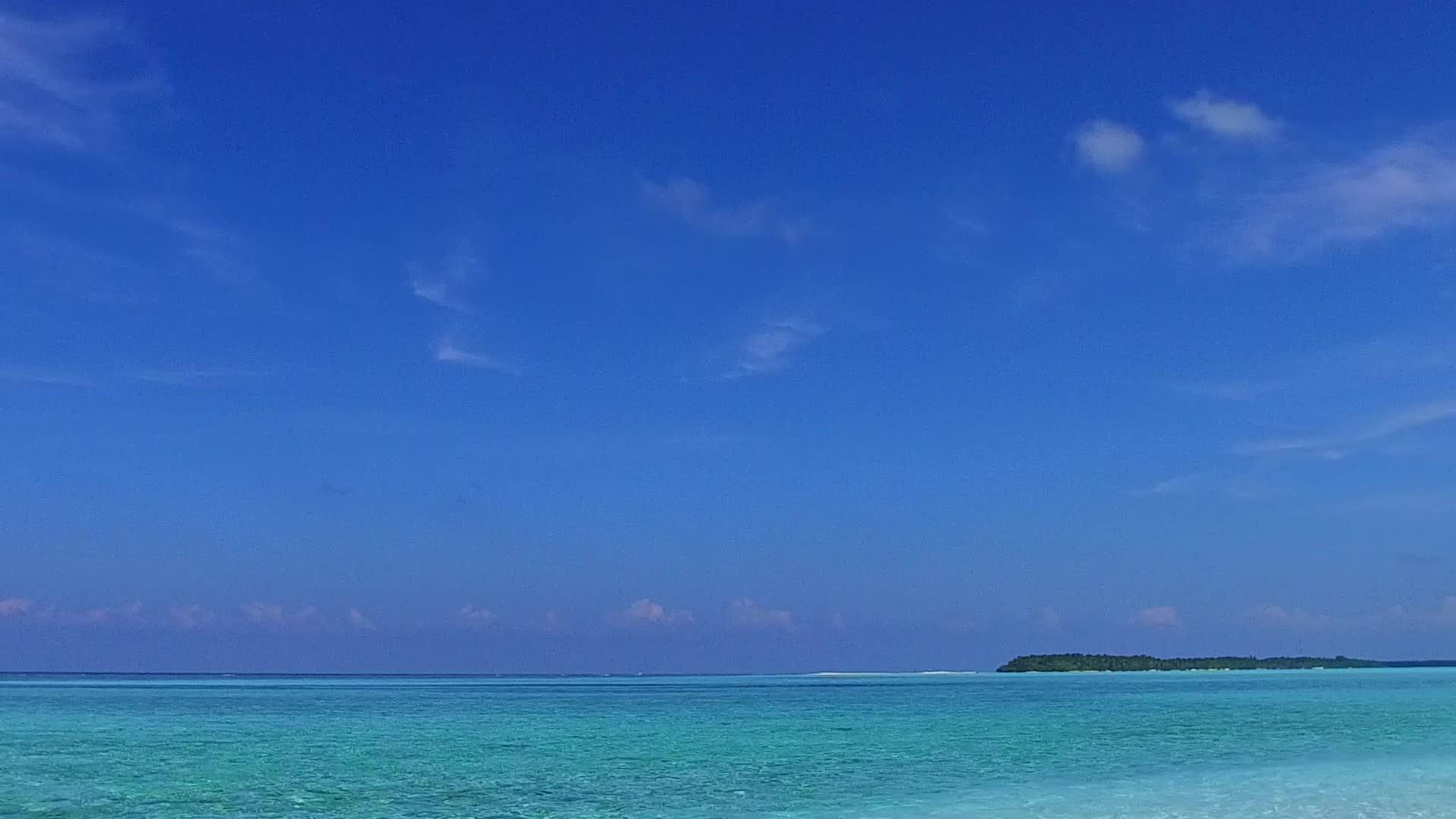 蓝水和珊瑚礁附近的白沙采集了阳光明媚的海滩视频的预览图