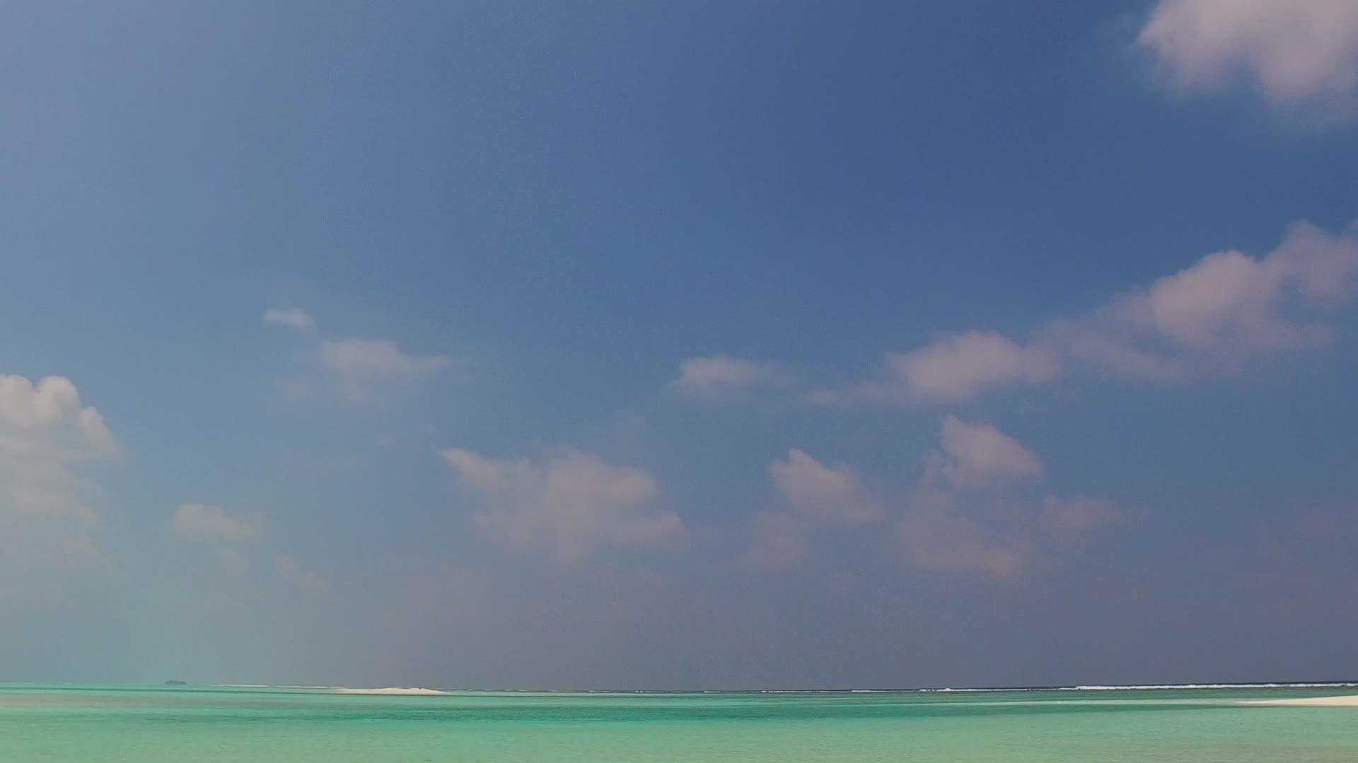 当海滩被海浪附近的白沙背景的绿松石环礁湖打破时阳光明媚视频的预览图