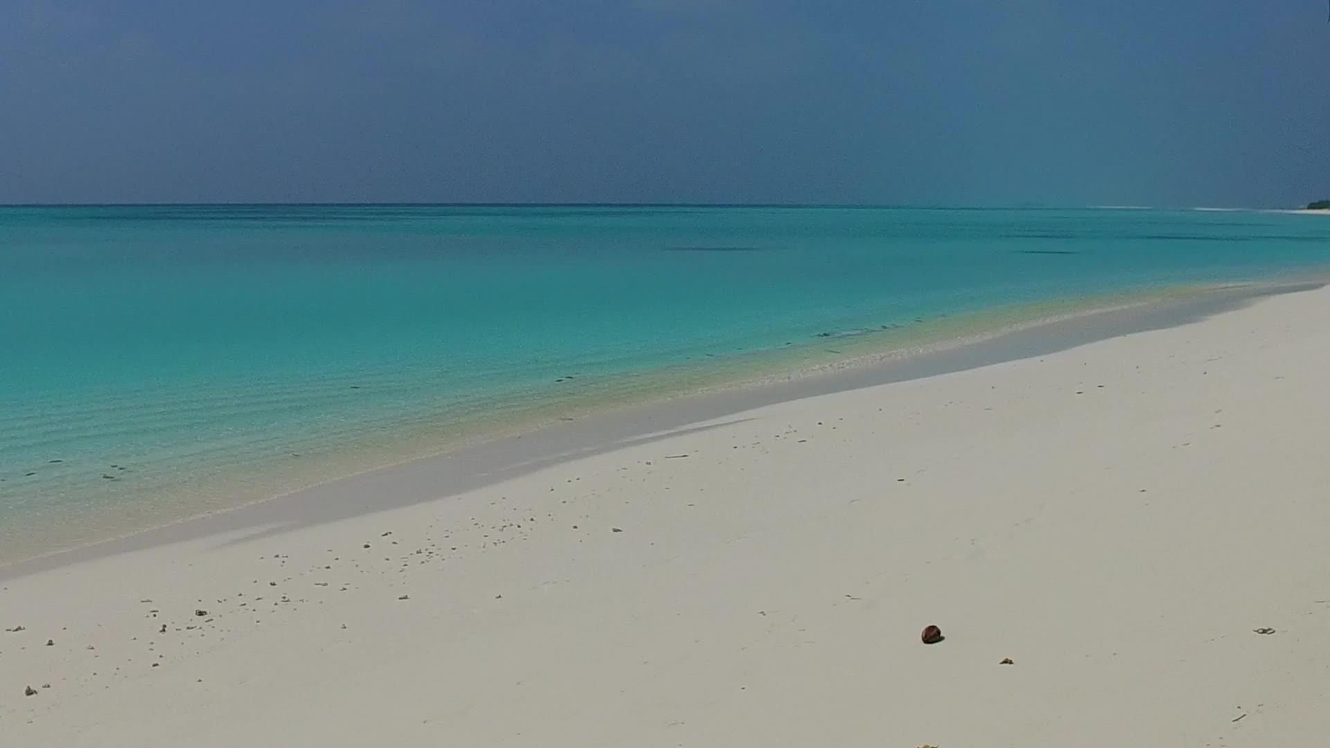 透明村附近的透明水和白色沙质背景打破了豪华的沿海海滩视频的预览图