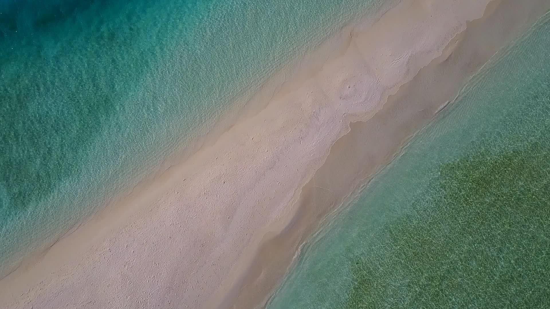以蓝绿水为主题探索阳光下白色沙滩背景的海滨海滩视频的预览图