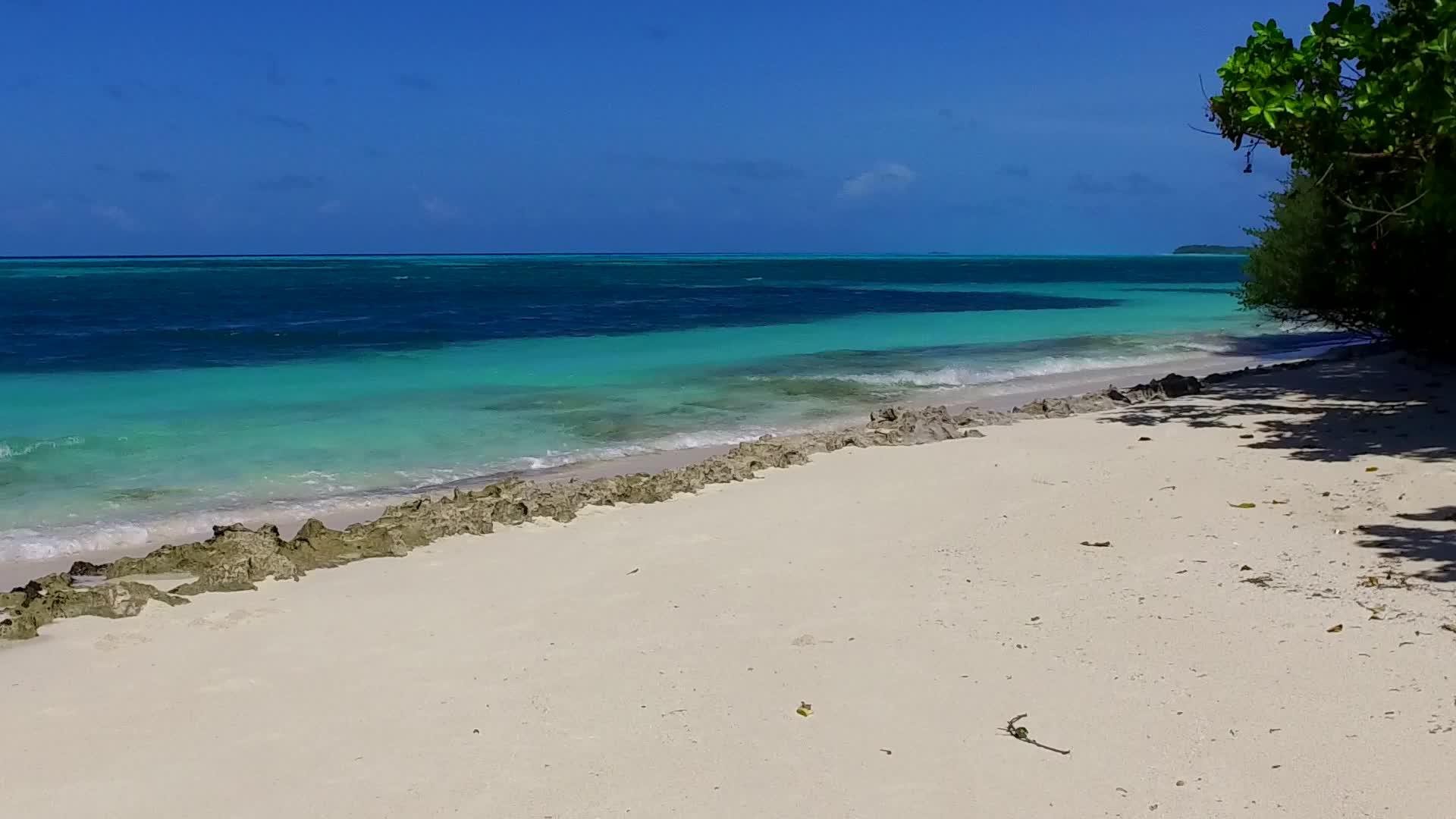 蓝海和阳光下的白沙背景靠近环礁湖的豪华海滩视频的预览图