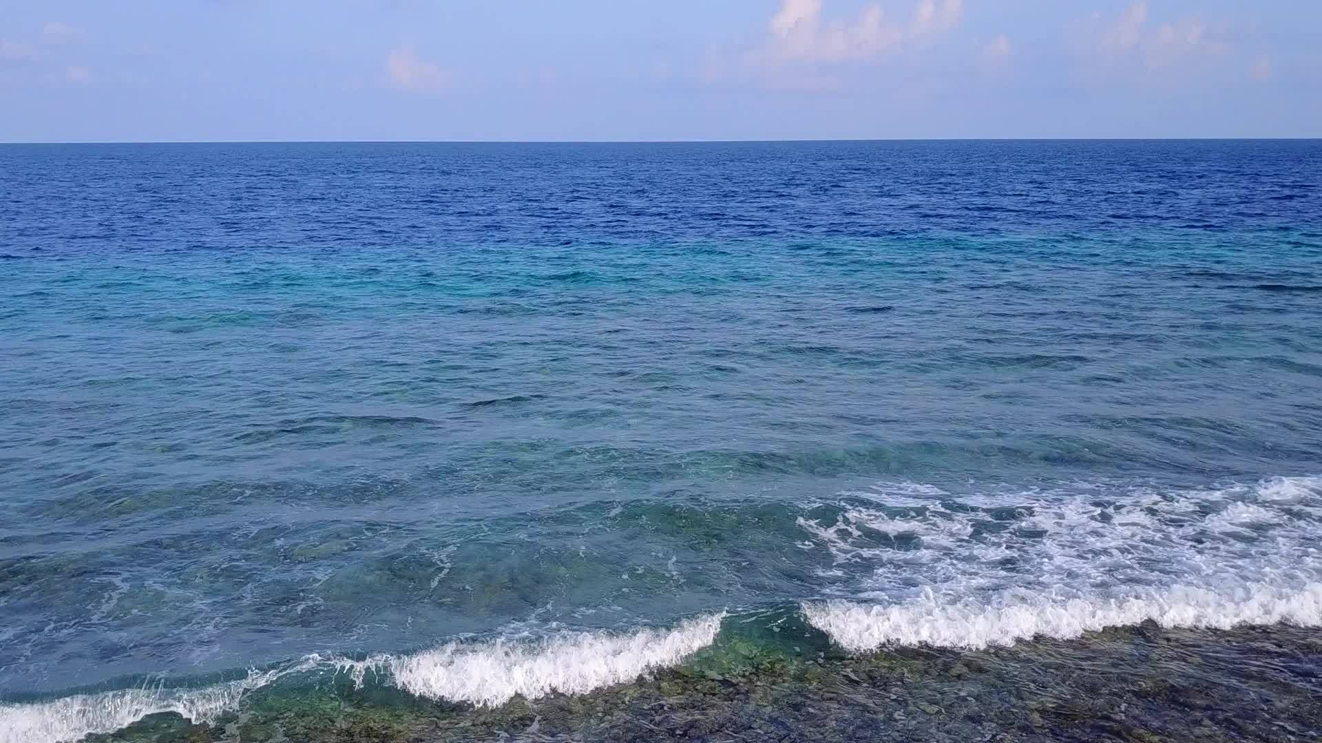 靠近度假胜地的蓝绿色海洋和干净的海滩背景明亮、阳光明媚视频的预览图