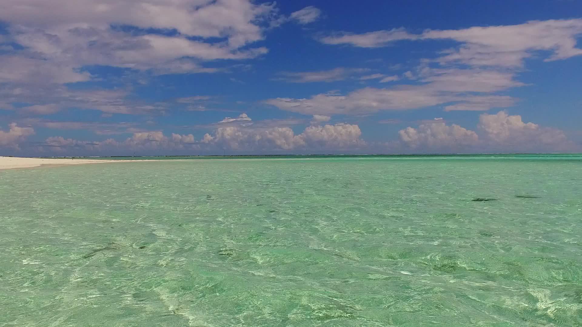 在白色海滩的背景下在浅海和阳光下完美地沿海滩航行视频的预览图