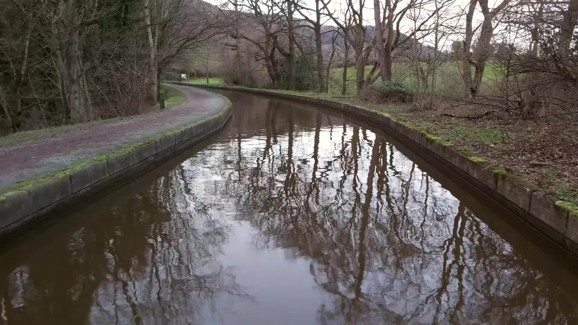 一艘狭窄的船在农村的一条英属运河上航行视频的预览图